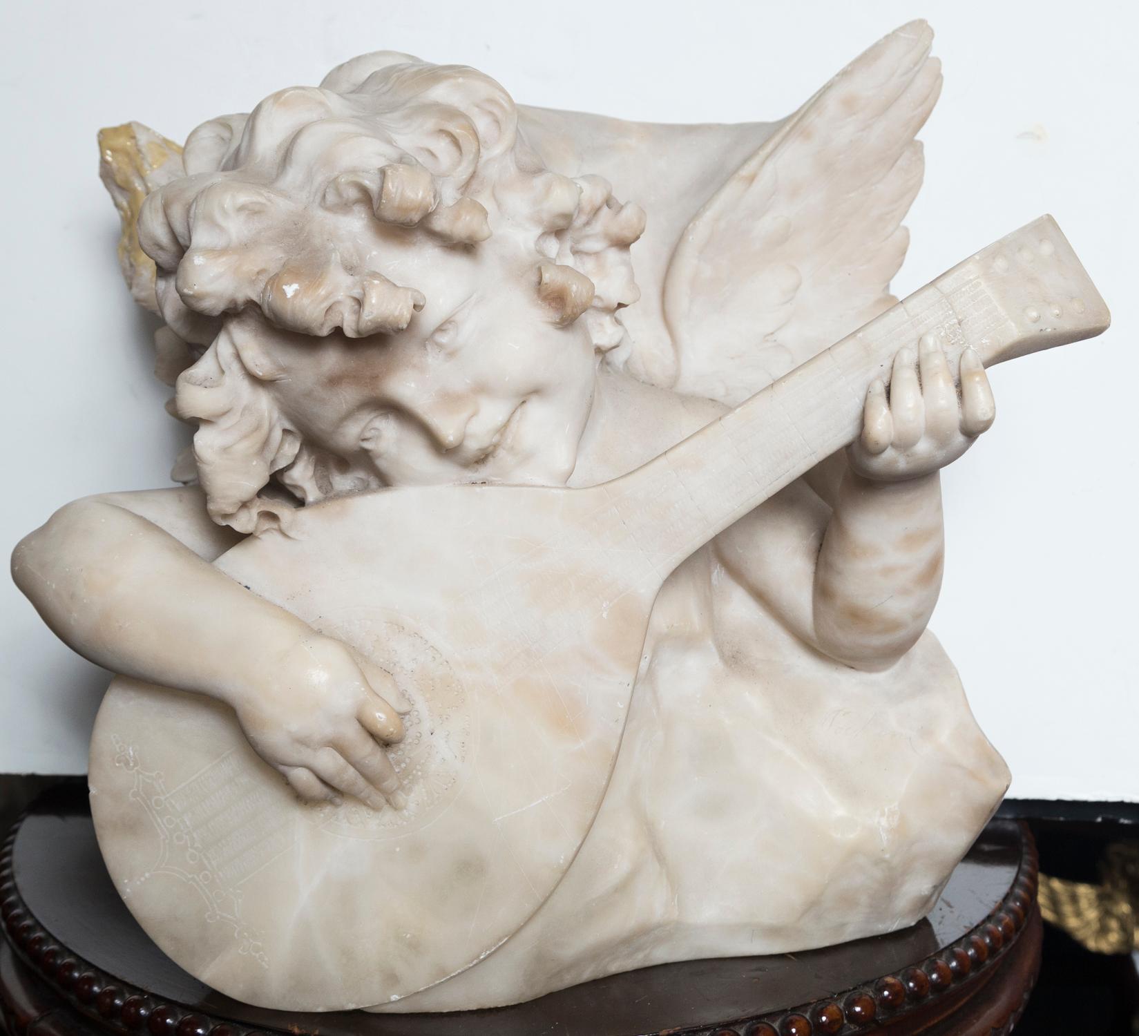 The whole carved from a single piece of white marble, in deep relief. The putto has wings and is playing a mandolin. His curly hair and smiling face very well carved. Damage to the left wing (facing the viewer) has been filled and the fill has