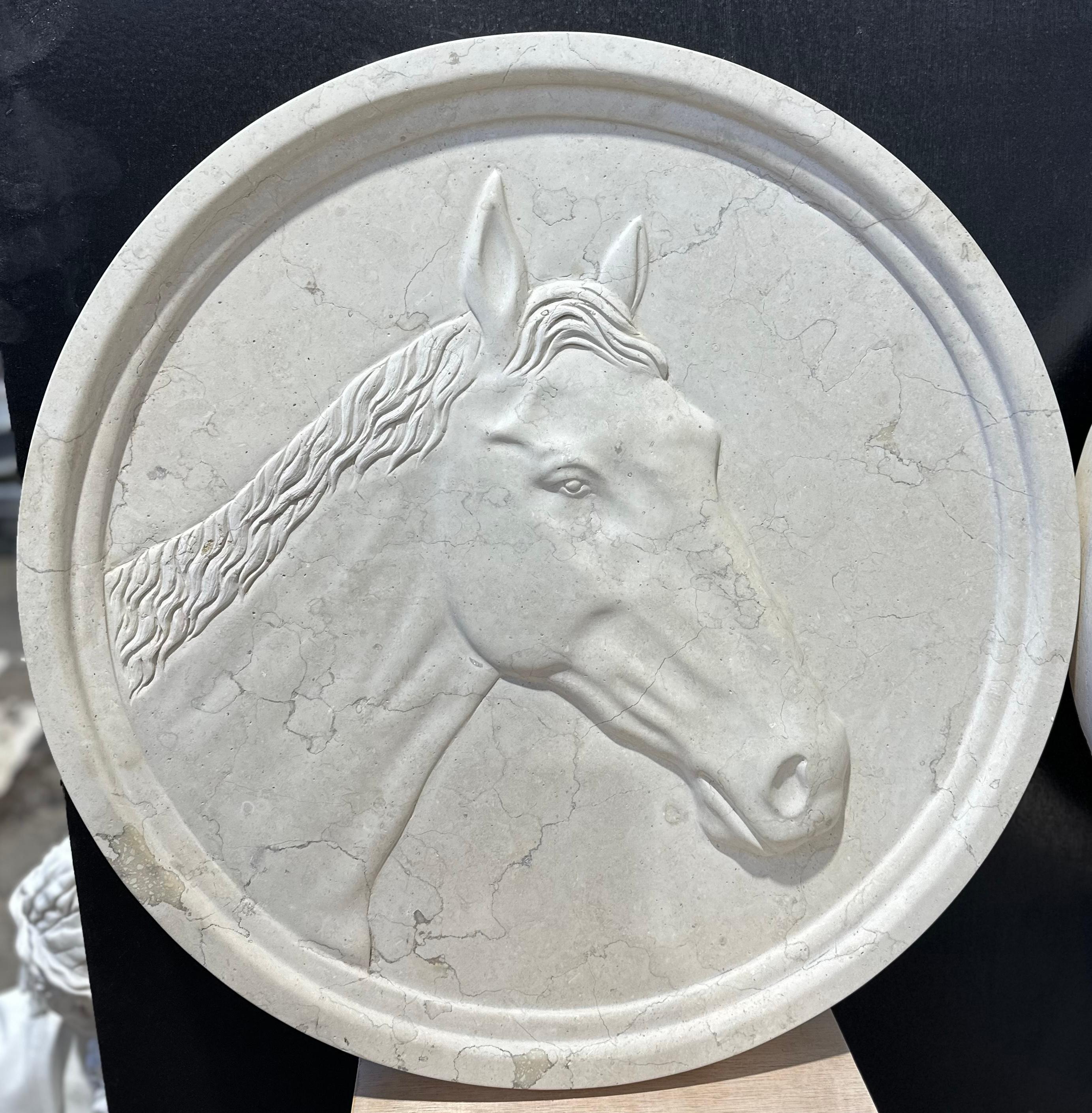 A beautifully hand carved pair of horse head marble wall plaques, one with a bridle. These are a lovely set with crisp carving to the horses head, detailing the bone structure and muscles. These would make a wonderful addition to any equestrian