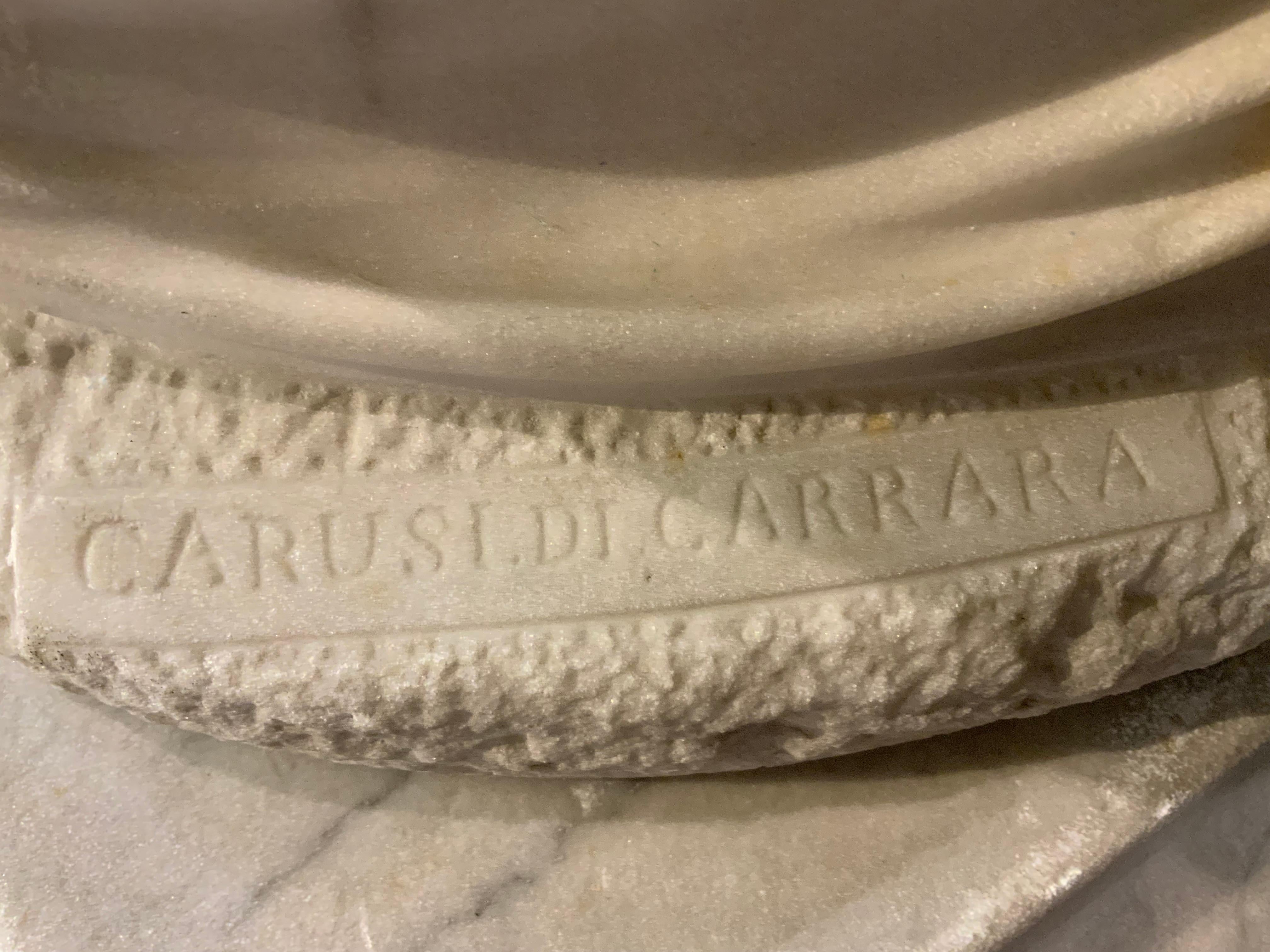 This sculpture is beautifully carved from carrara
Marble and is made to fit the marble pedestal
It is signed Carusi at the base. She is holding her 
Dog and has a finger held to her lips. No breaks or
Restorations   Carusi was a sculptor in the 19th