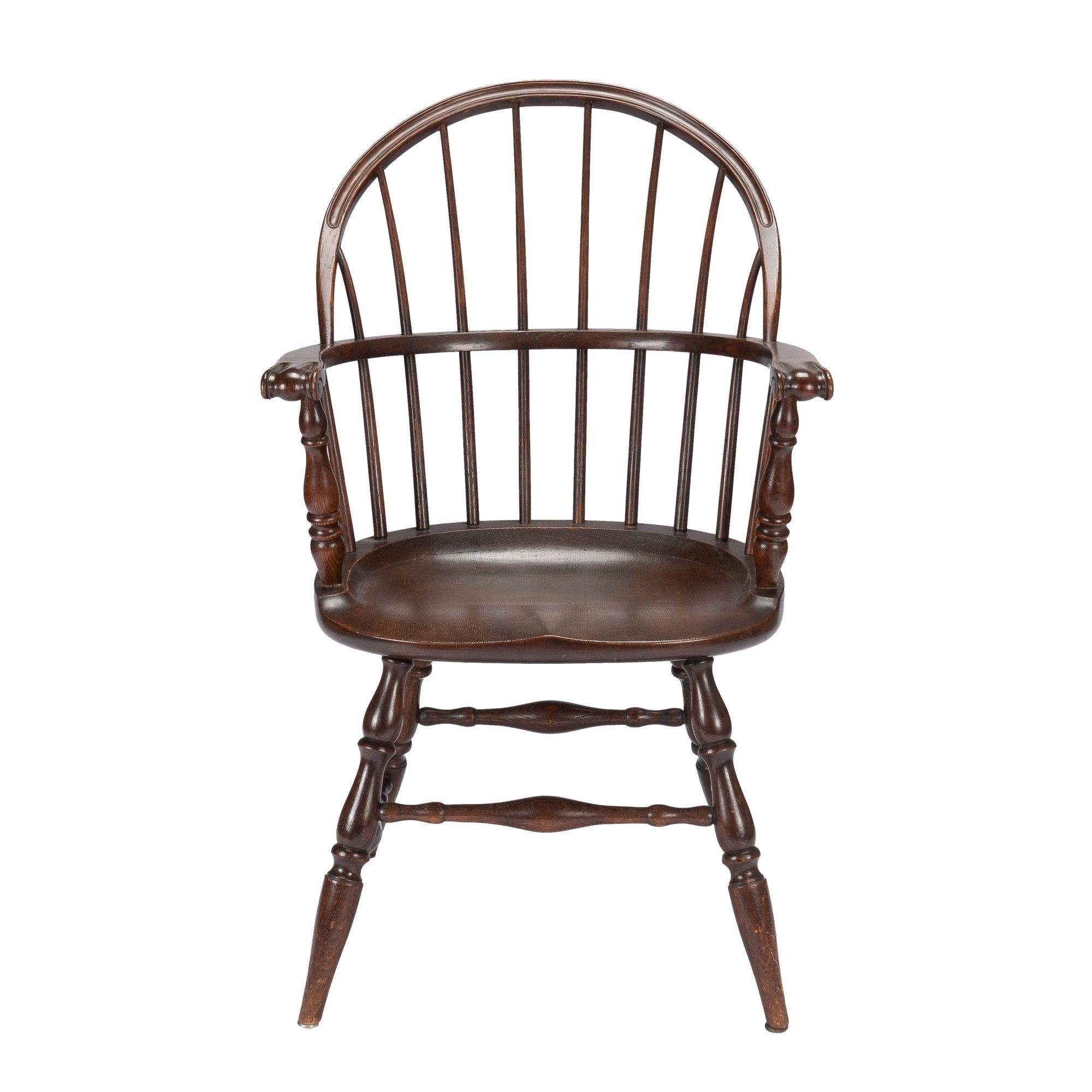 Academic Revival eight spindle bow back Windsor armchair in white oak. The chair bears its original makers label on the under side of the seat. 
American, Ohio, circa 1920.