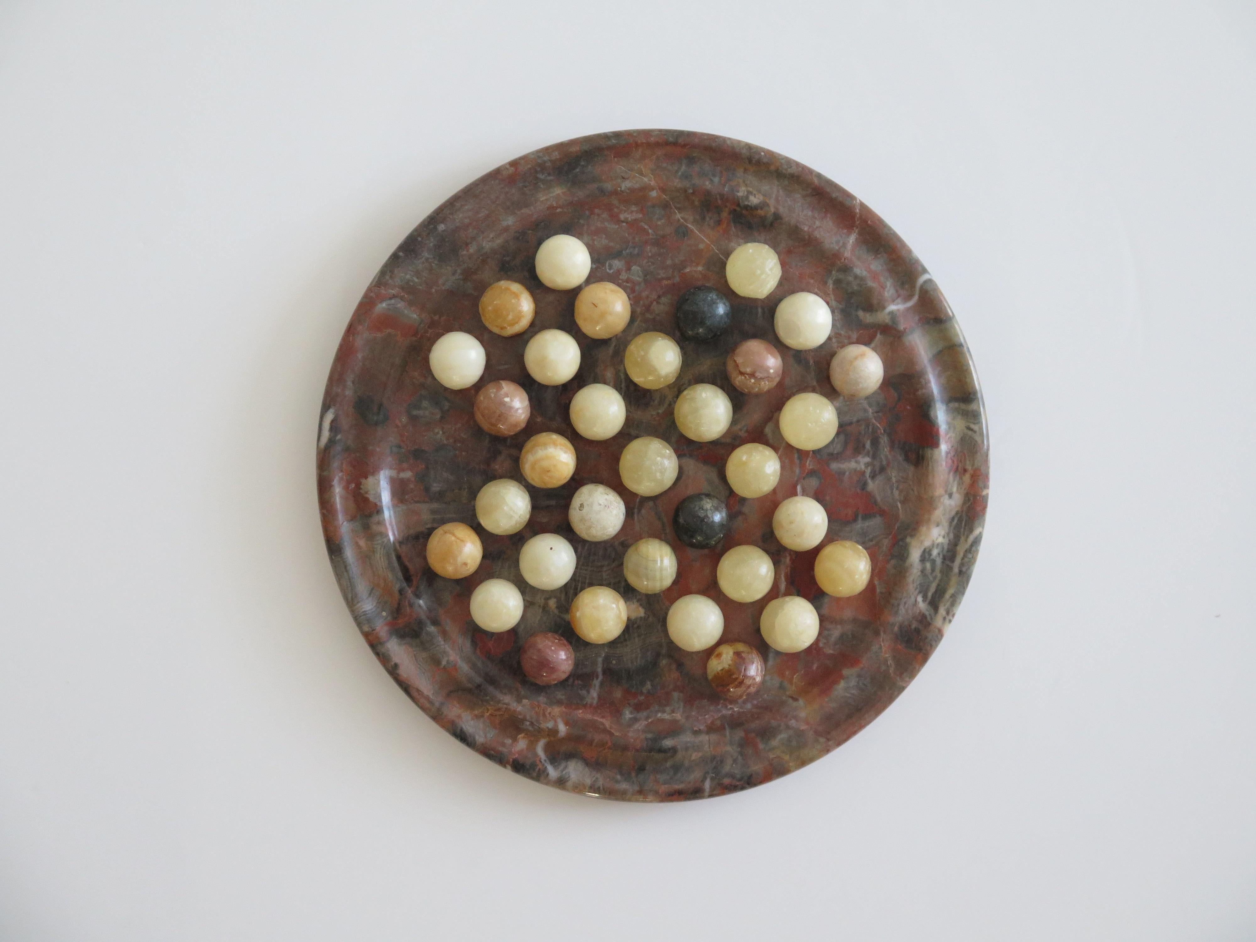 This is a very good complete board game of marble solitaire with a beautiful marble natural stone board and 33 agate mineral stone marbles which we date to the first half of the 20th century, Circa 1930s.

This is a heavy piece, weighing about 2 Kg