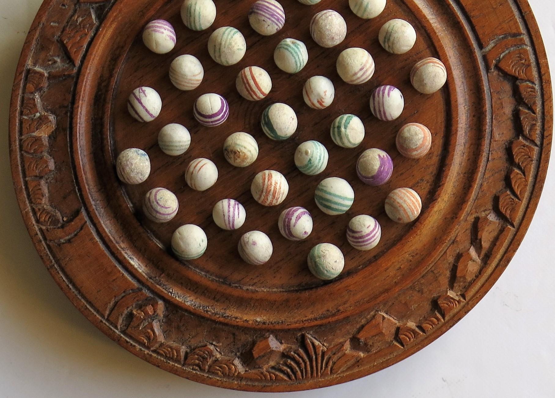 Carved Marble Solitaire Board Game with 37 Early Handmade Ceramic Marbles, circa 1870
