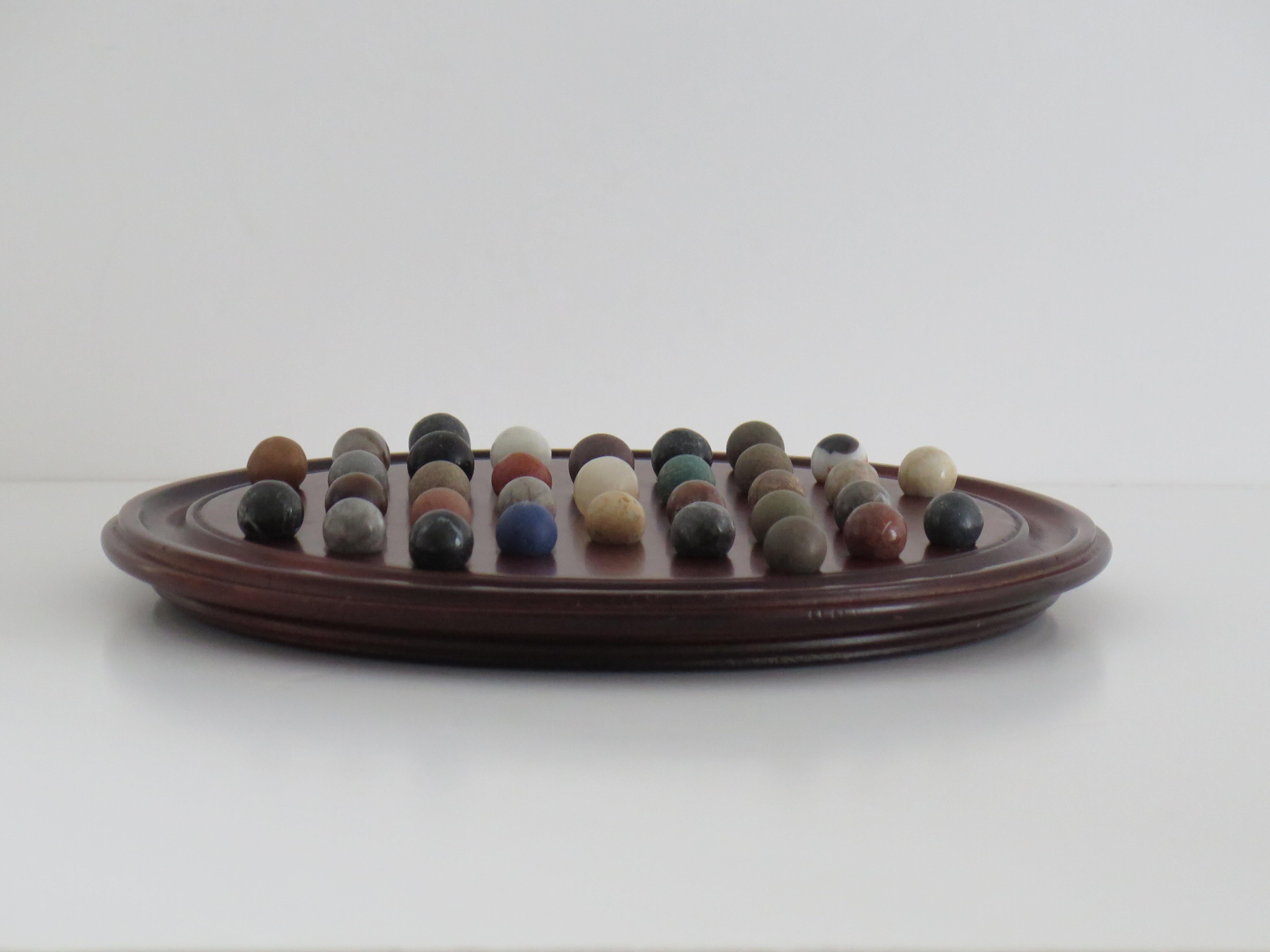 20th Century Marble Solitaire Game 10 inch Hardwood Board 35 mixed Stone Marbles, circa 1945 For Sale
