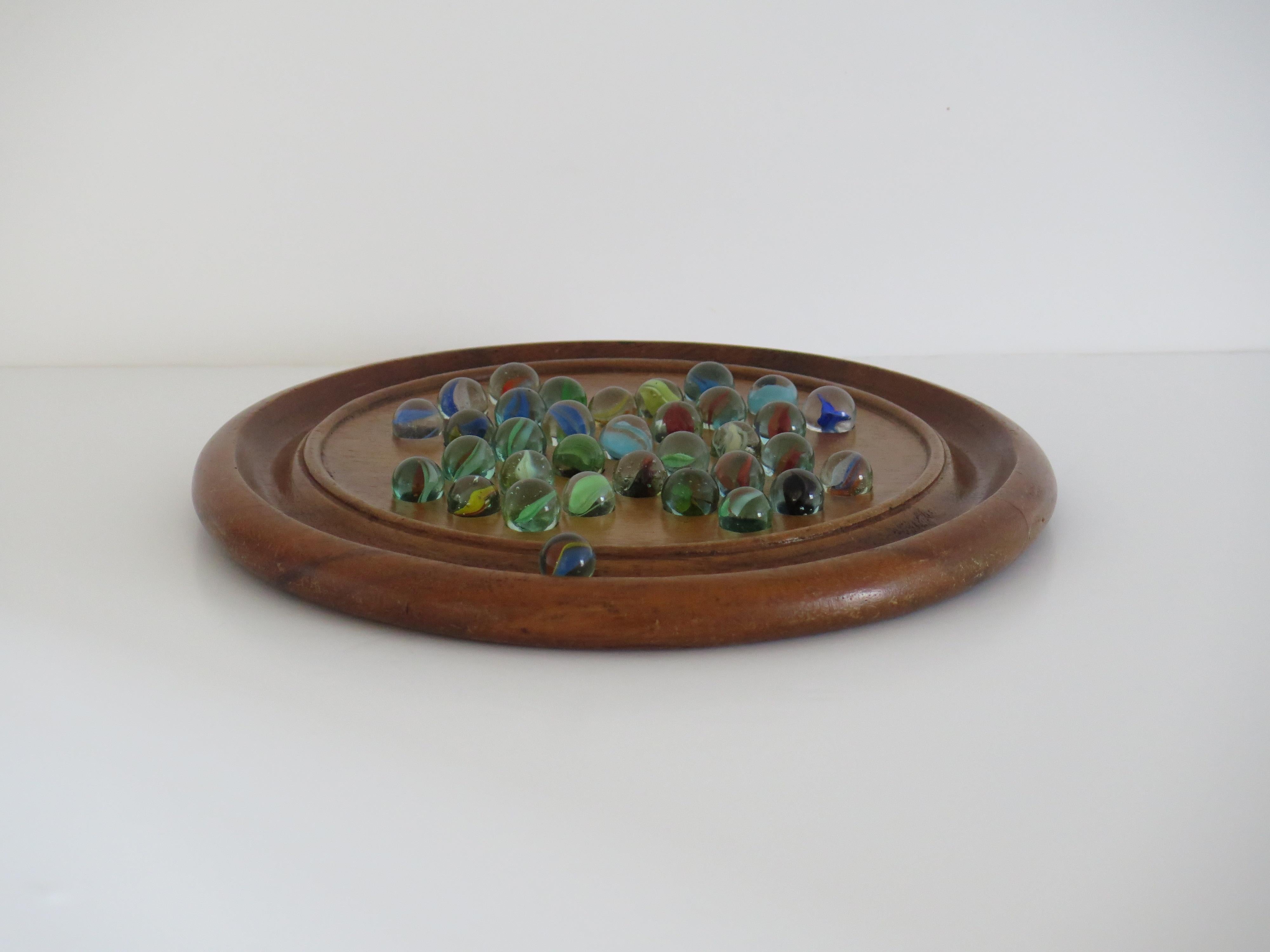 Juego de solitario de canicas Tablero de madera dura con 34 canicas antiguas de cristal arremolinado, Circa 1930 Inglés en venta