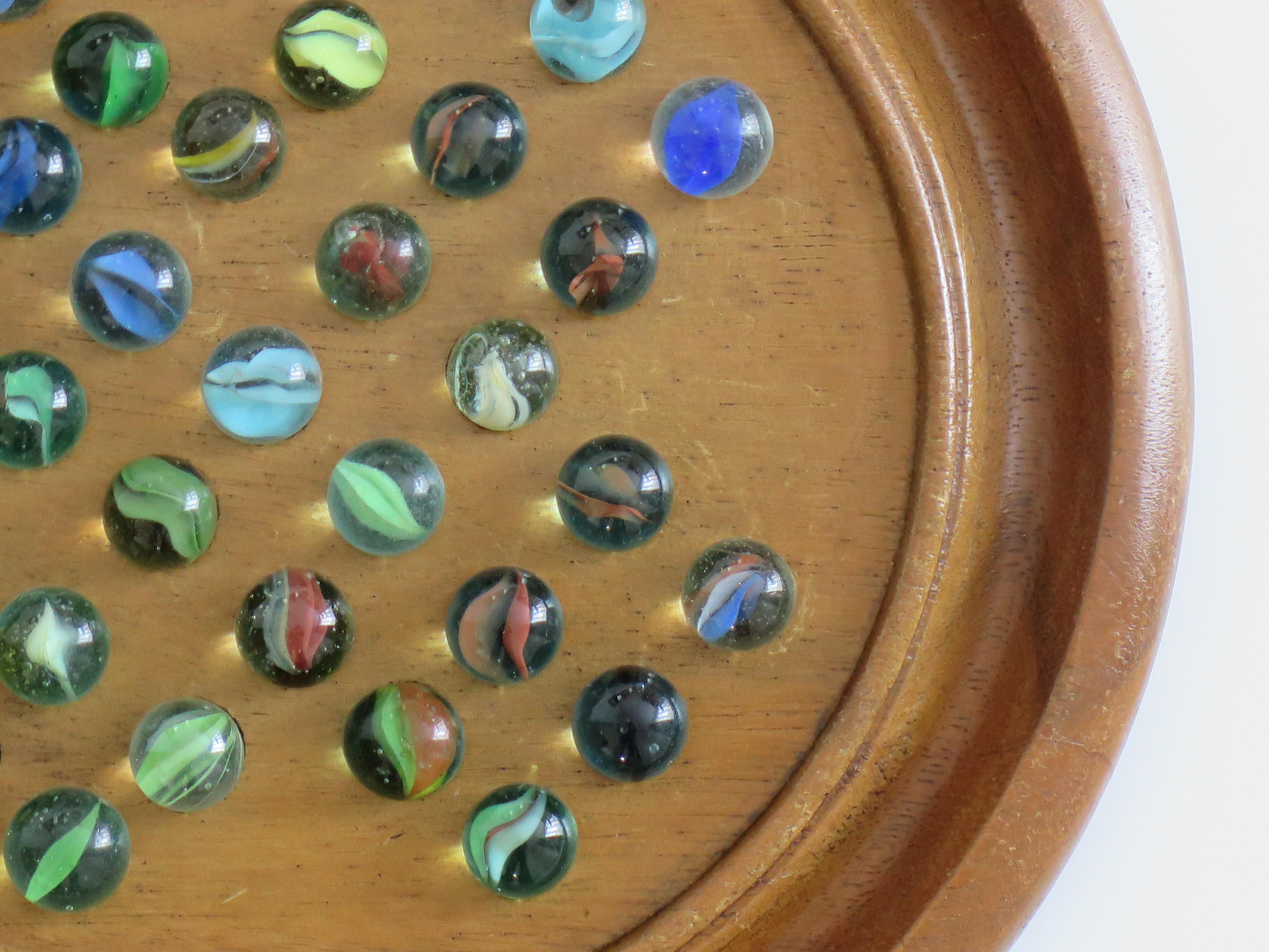 Juego de solitario de canicas Tablero de madera dura con 34 canicas antiguas de cristal arremolinado, Circa 1930 Vidrio en venta