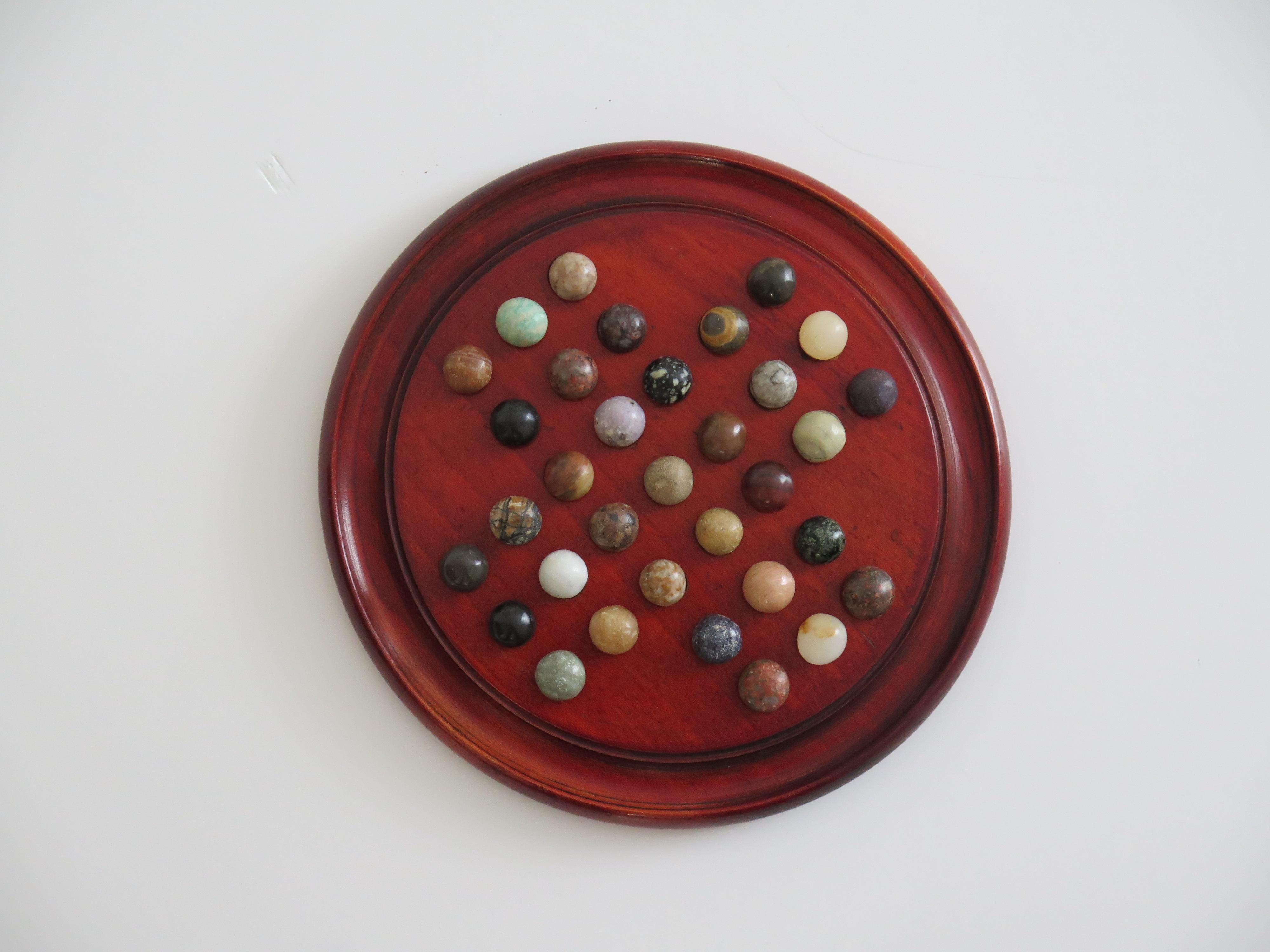 This is a very good and complete board game of Marble Solitaire, with a hand turned hardwood board and 33 agate stone marbles, which we date to the Art Deco period of the 20th Century, Circa 1925.

The circular turned board is made of hardwood,