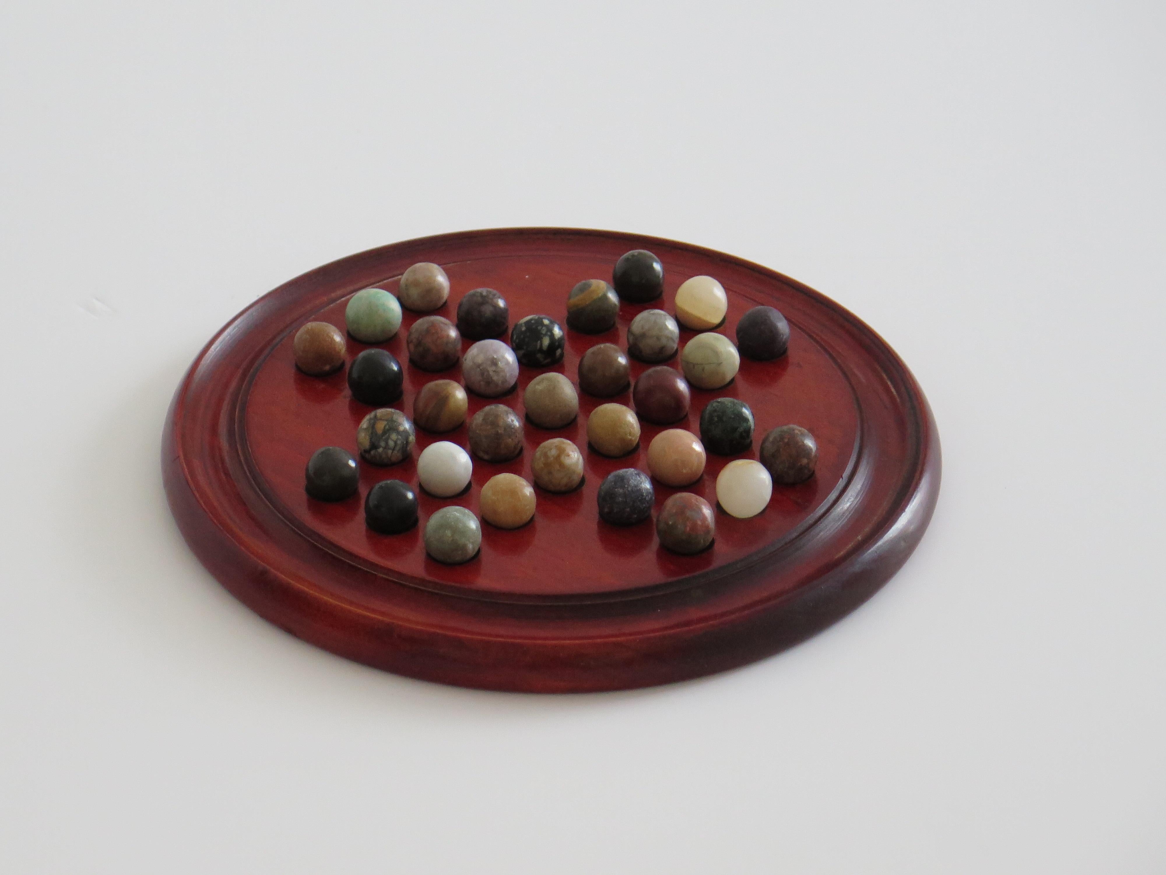 English Marble Solitaire Game with hardwood board and 33 agate stone Marbles, Circa 1925 For Sale