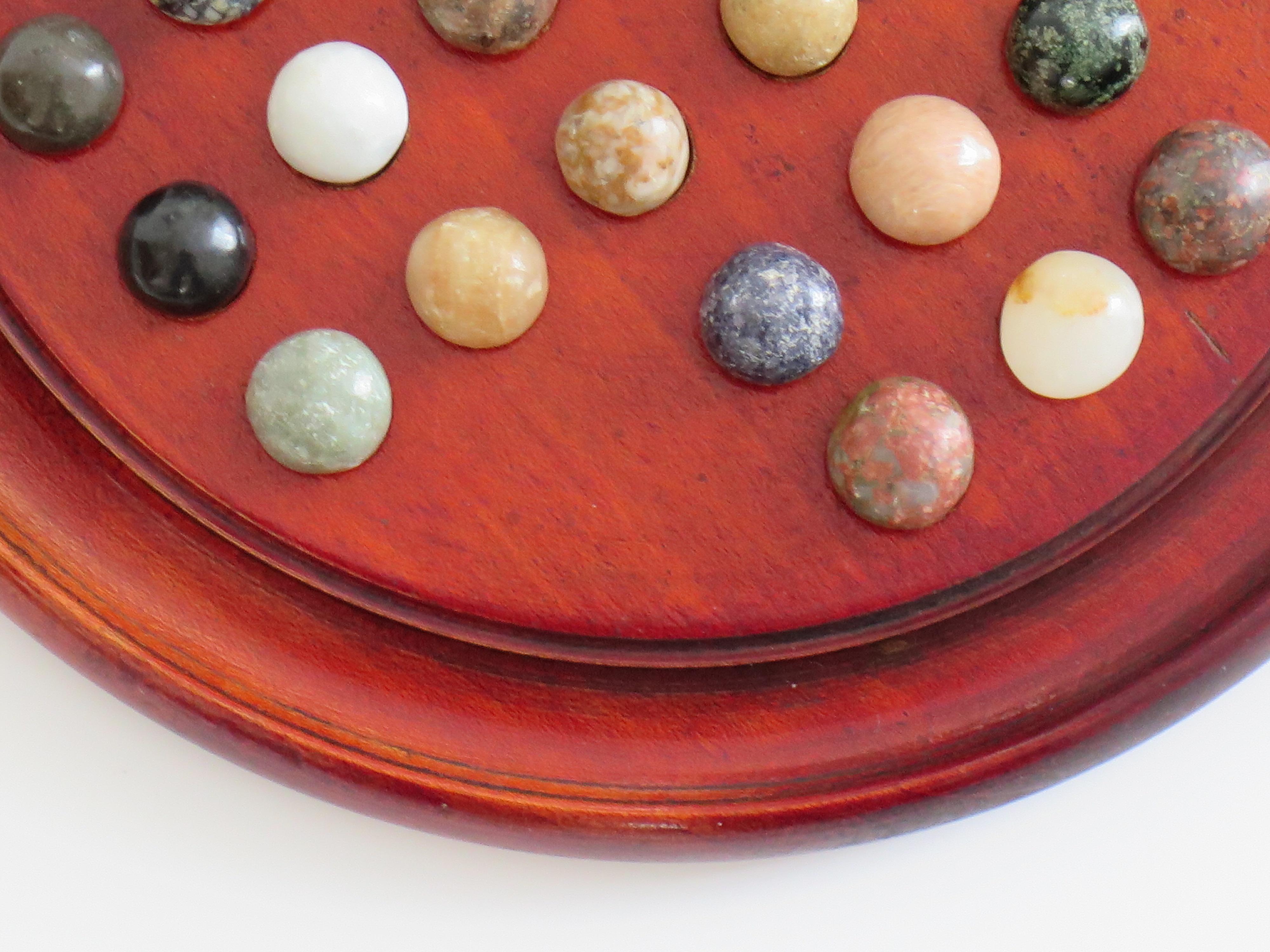 Stone Marble Solitaire Game with hardwood board and 33 agate stone Marbles, Circa 1925 For Sale