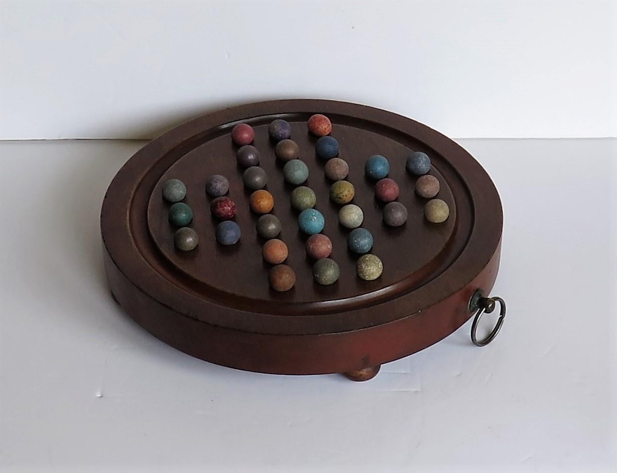 English Marble Solitaire Hardwood Board with Hanging Ring 33 Clay Marbles, circa 1860
