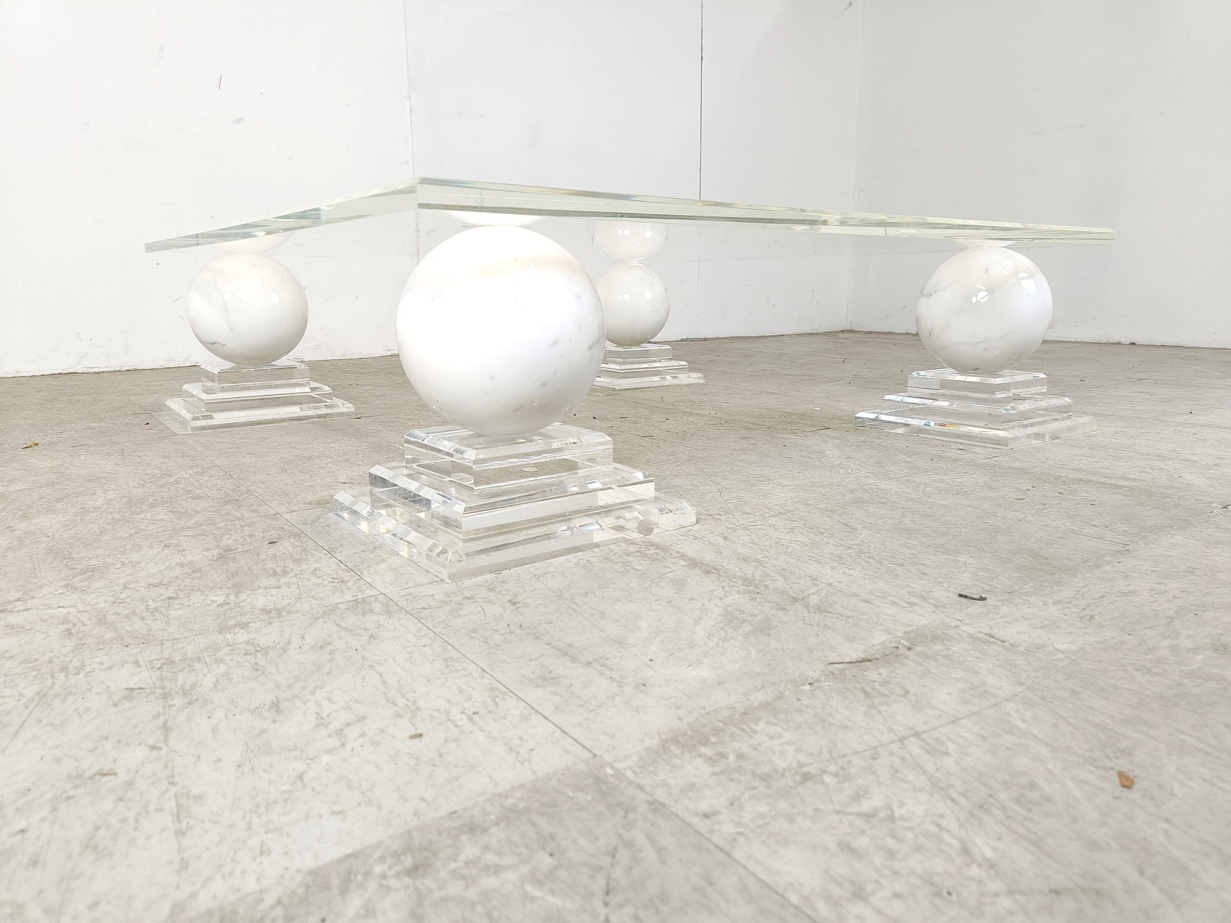 Gorgeous vintage coffee table with 4 white marble spheres mounted on stepped lucite bases topped with a a plexiglass table top.

Beautiful, timeless piece.

If desired we can supply a glass top for this coffee table instead of the original plexi