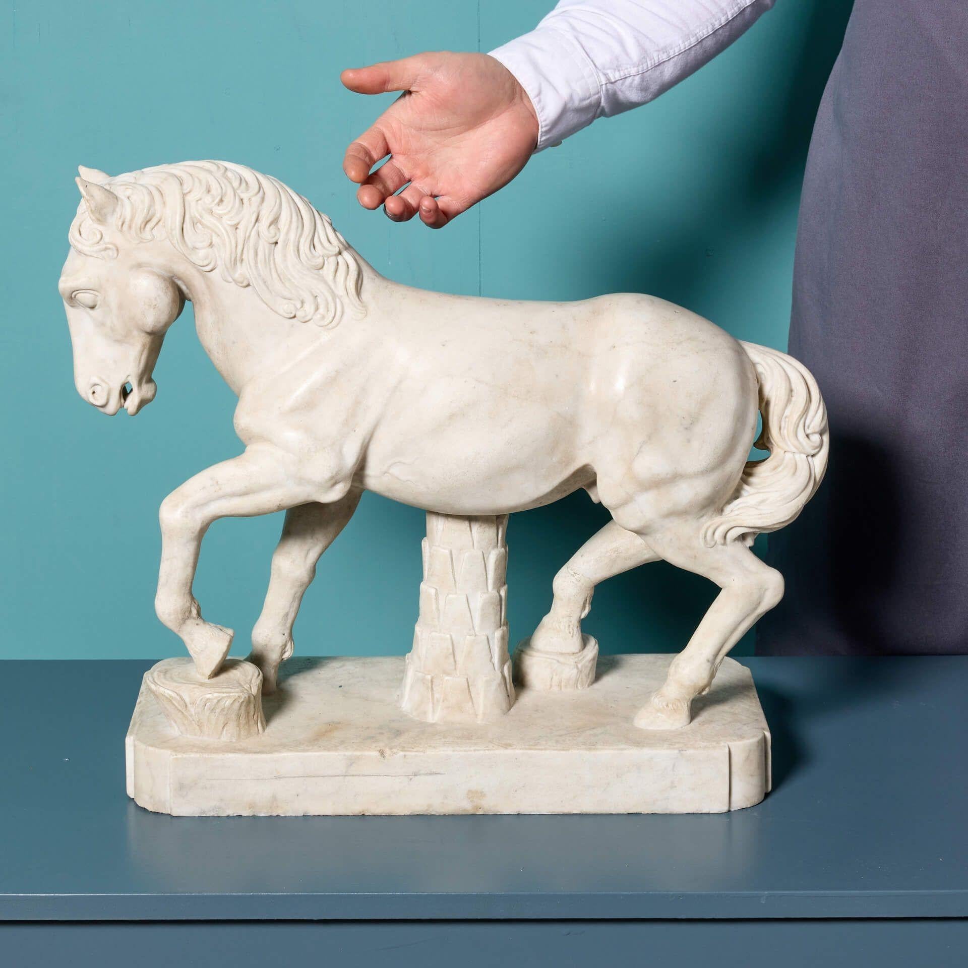 Un'elegante statua in marmo dello stallone corridore dopo l'antico di Alceo Doessena. Ispirato ai Cavalli di San Marco a Venezia, questo stallone splendidamente intagliato è una testimonianza dell'abilità artistica di Dossena. In stile all'antica,