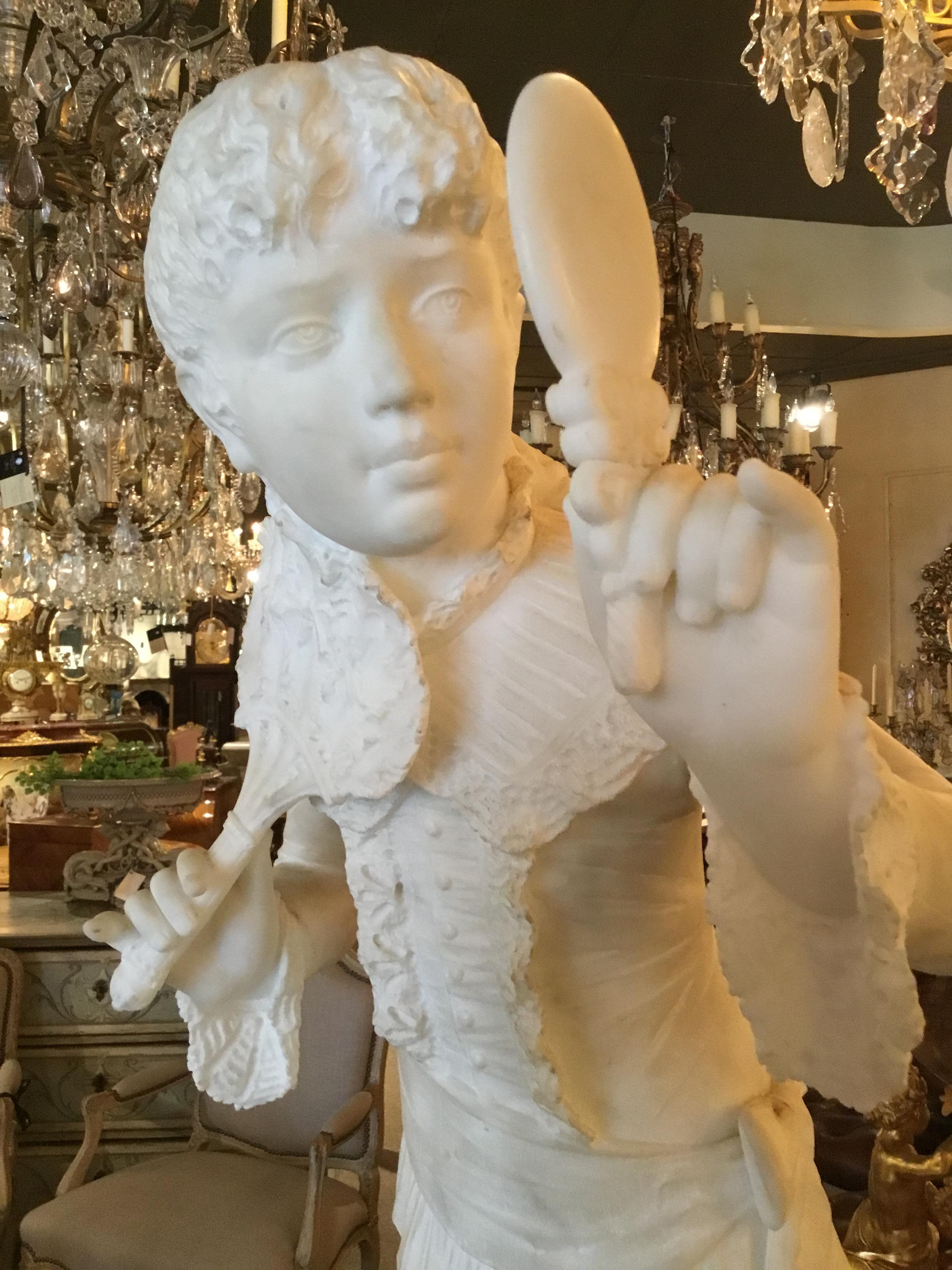 Lovely statue of a young girl gazing into a mirror and holding a hand fan.
Well carved.