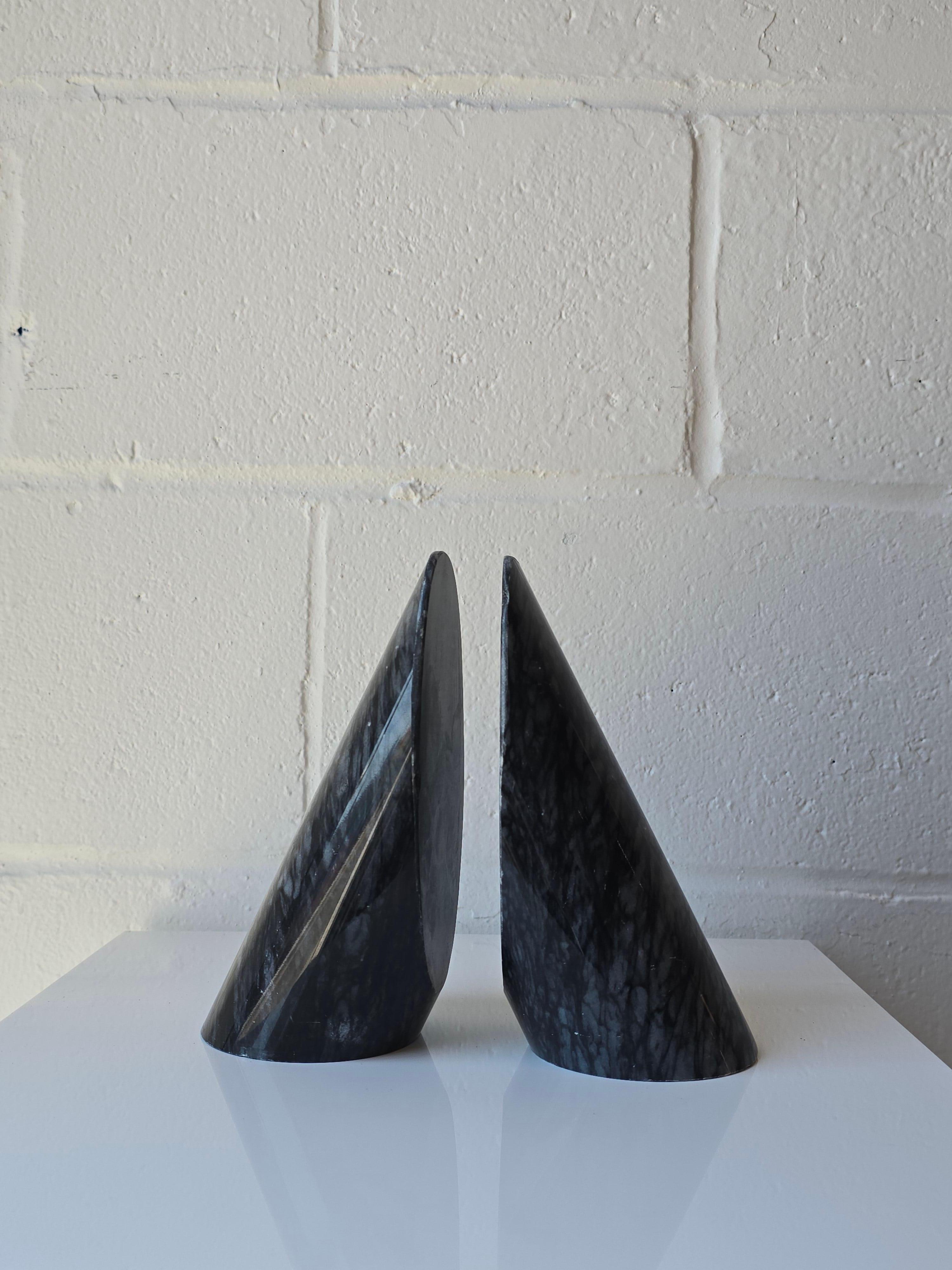 Gorgeous pair of marble stone bookends.
The marble which is a stone that has beautiful veining and a coloring throughout. These bookends come as a pair and form a  tilted cylinder shape. They can be used as bookends to hold books or simply as decor