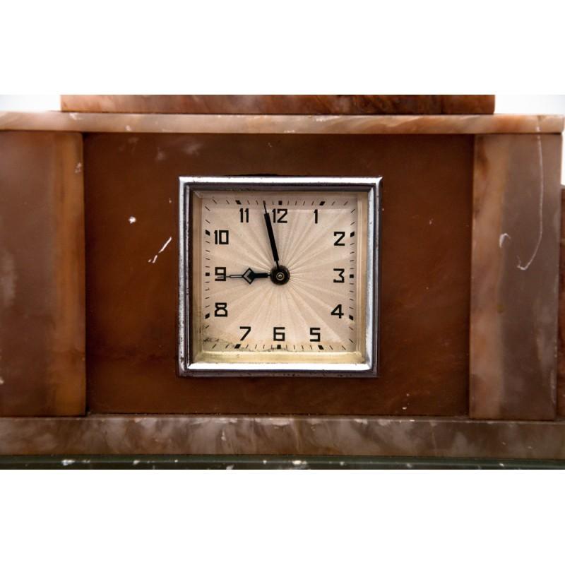 Die Tischuhr aus rosa und grünem Marmor stammt aus Polen, etwa aus den 1950er Jahren.
Braune Vogelskulptur auf der Oberseite.
Uhrwerk vom Uhrmacher geprüft, voll funktionsfähig.
 