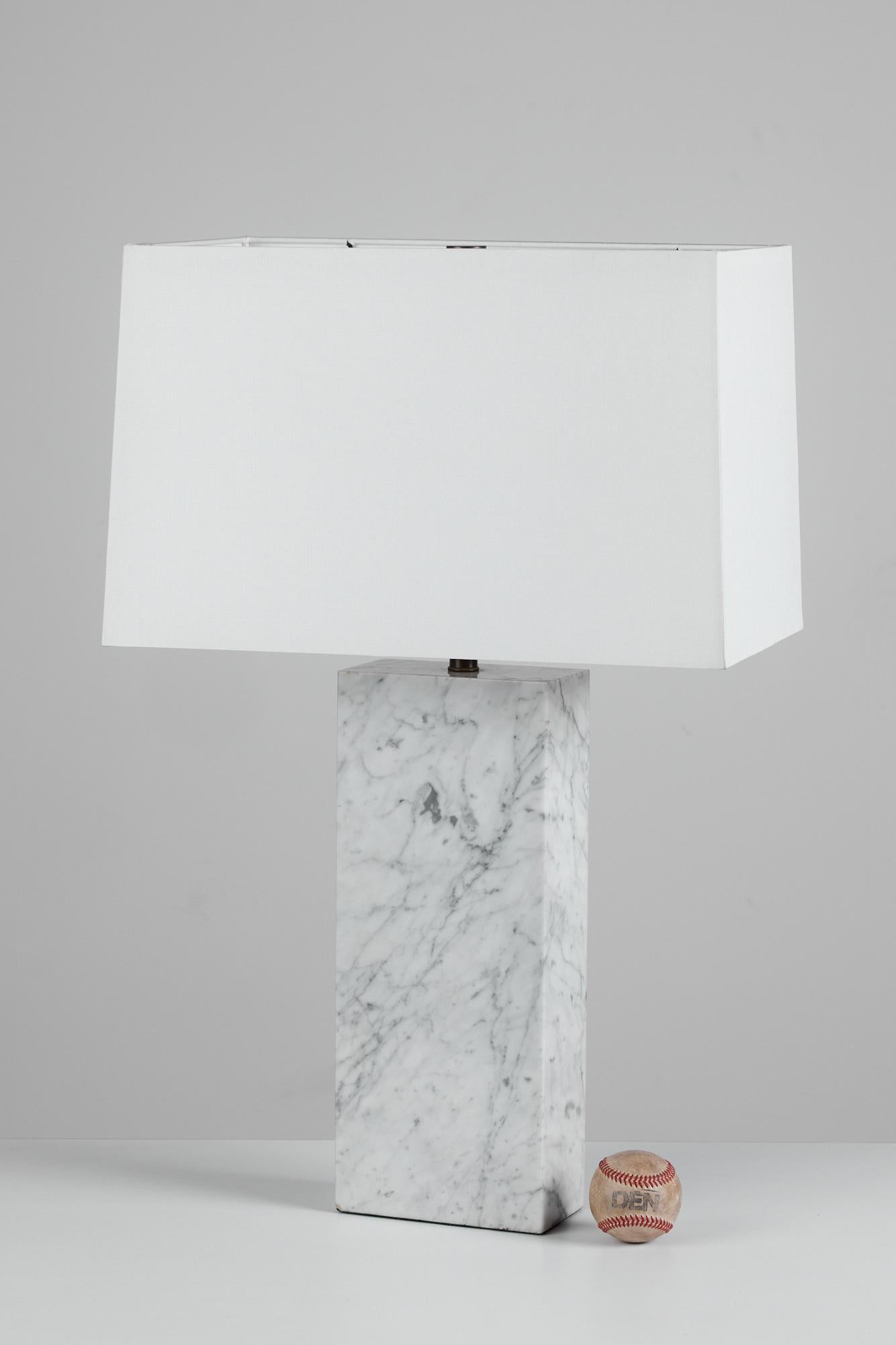 Table lamp with a rectangular carved marble base in the style of Robsjohn-Gibbings. The newly rewired; lamp features a new silk lamp shade. The shade and diffuser is secured by a patinated bronze finial.

Dimensions: 7