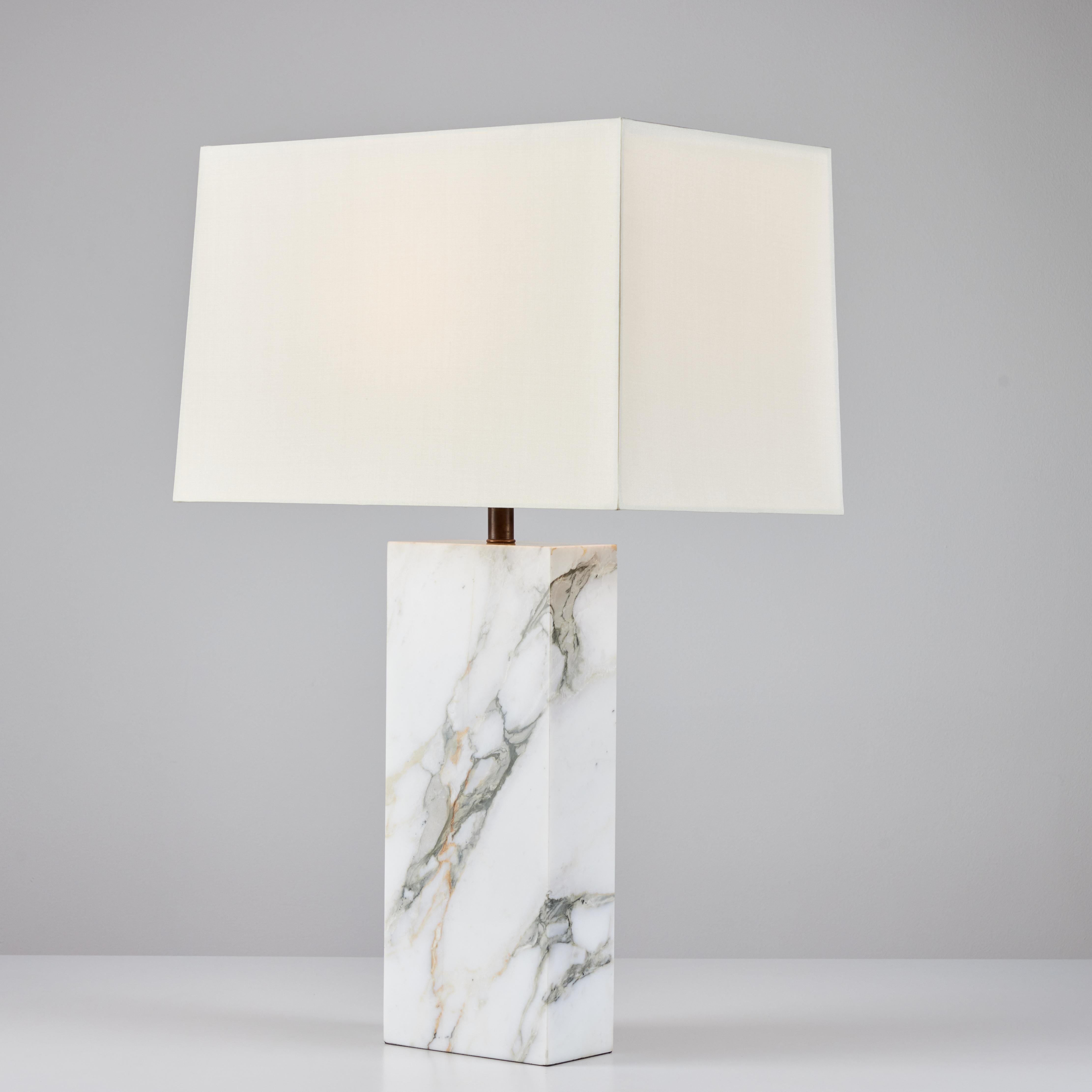 Table lamp with a rectangular carved marble base in the style of Robsjohn-Gibbings. The newly rewired; lamp features a new silk lamp shade. The shade and diffuser is secured by a patinated bronze finial.

Dimensions
7