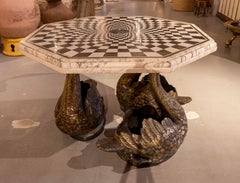 Mesa de mármol con incrustaciones geométricas de piedra y bases