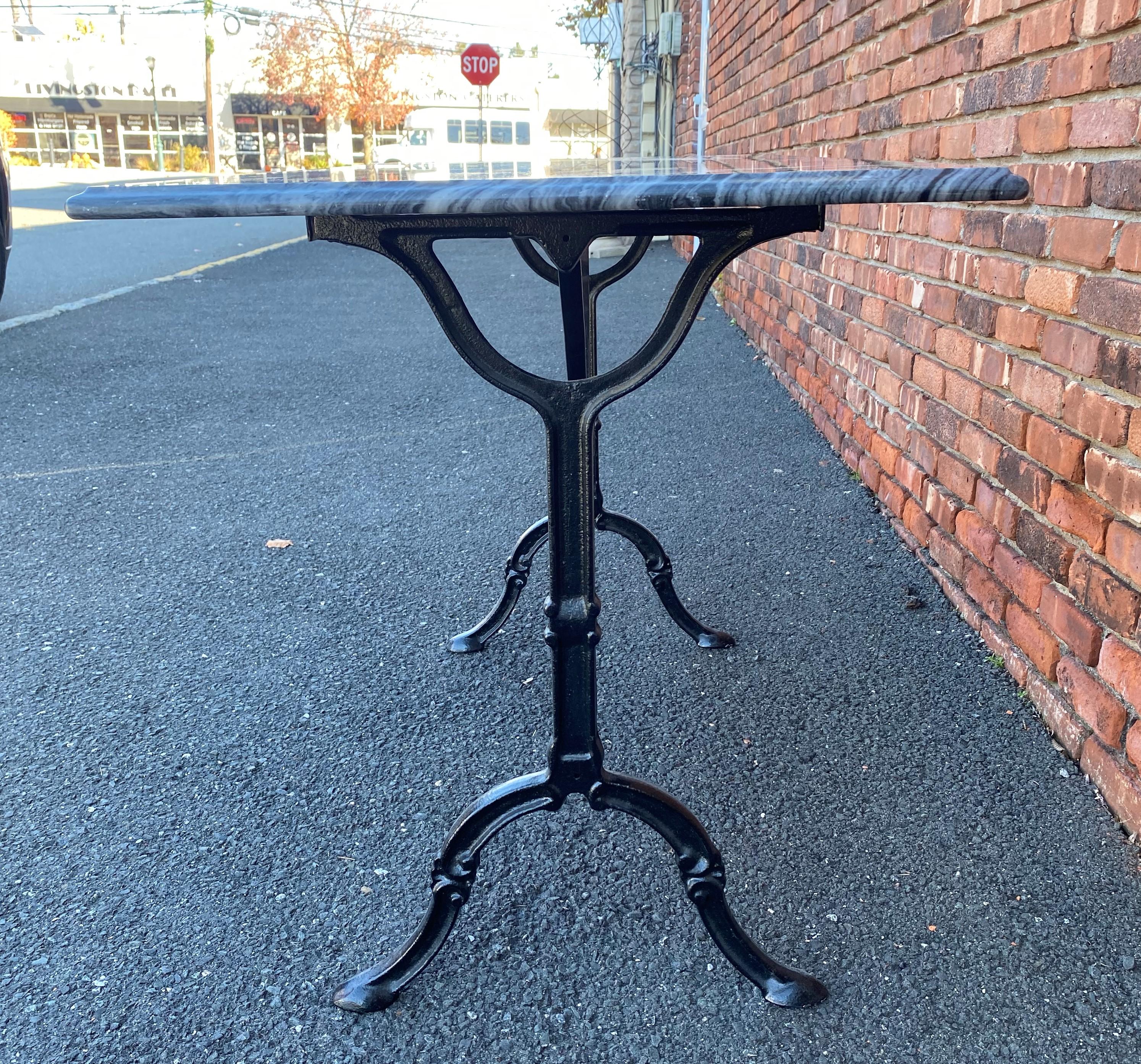 Vintage French marble-top bistro table. Iron base painted glossy black with a beveled edge black and grey marble top. The top is removable. This table can be used inside of outside. A great size that can even work as a writing desk of a console