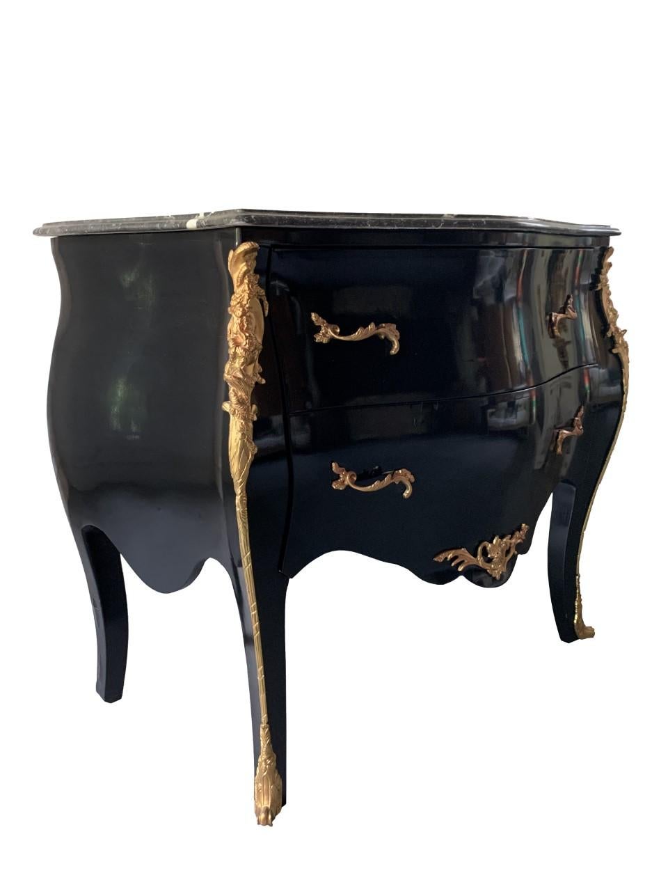 Marble top chest of drawers with brass accent.