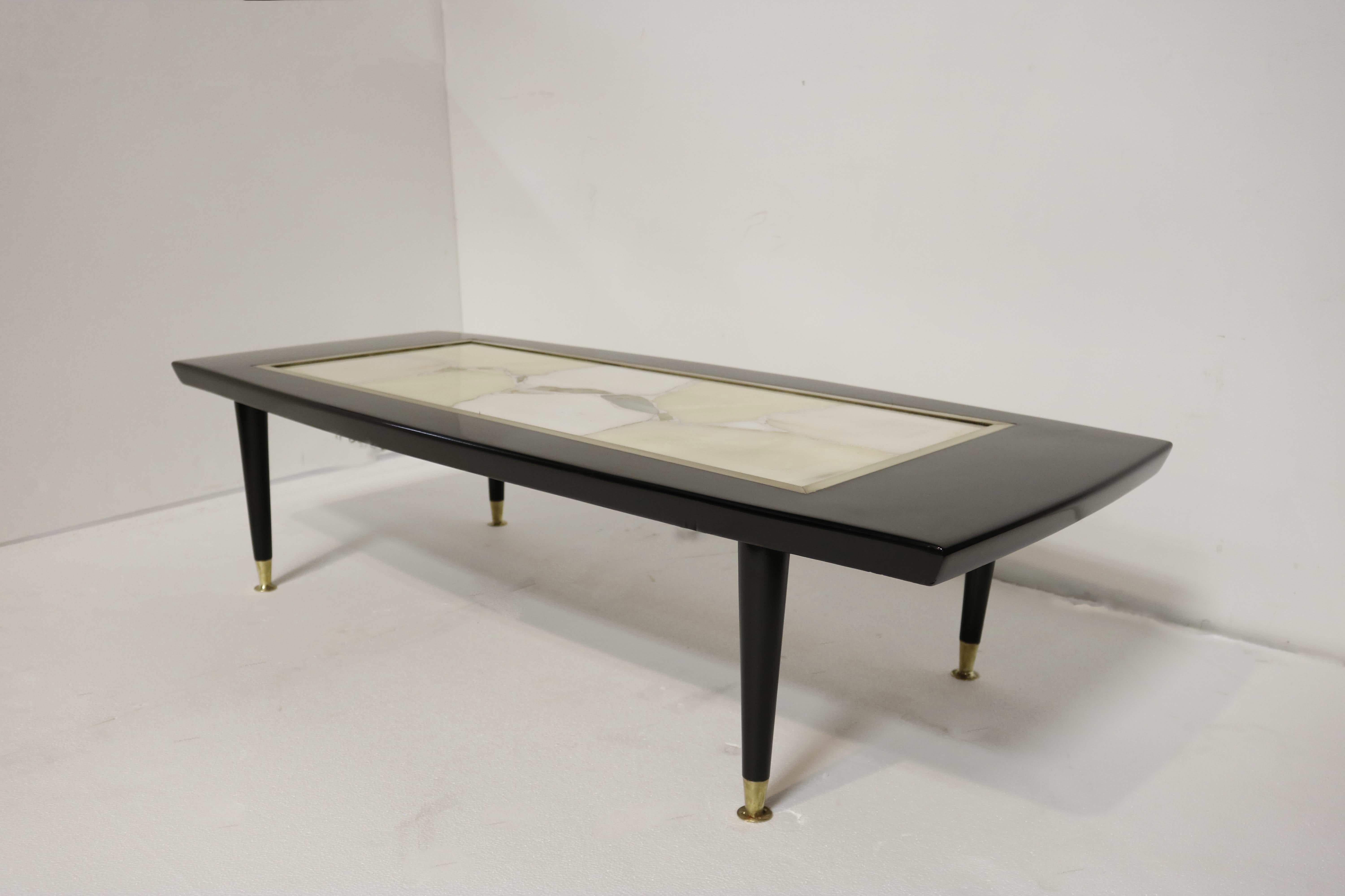 Sophisticated black lacquer coffee table with a magnificent marble centerpiece encased in its top
The marble slab is surrounded by a brass trim.