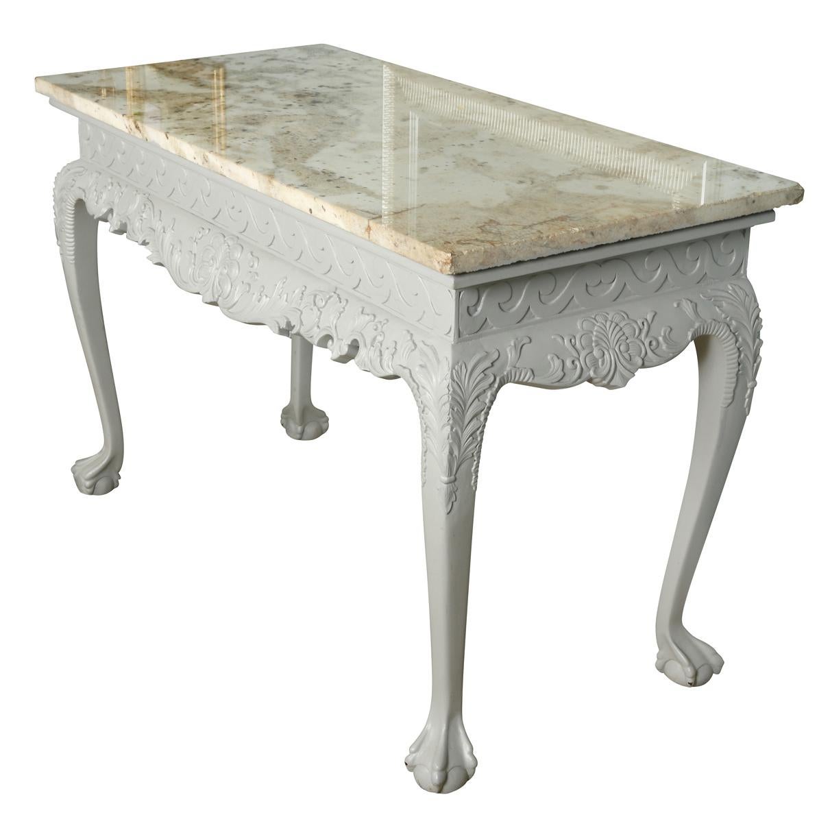 Gray painted ornate console table with claw and ball feet and a cream marble top.