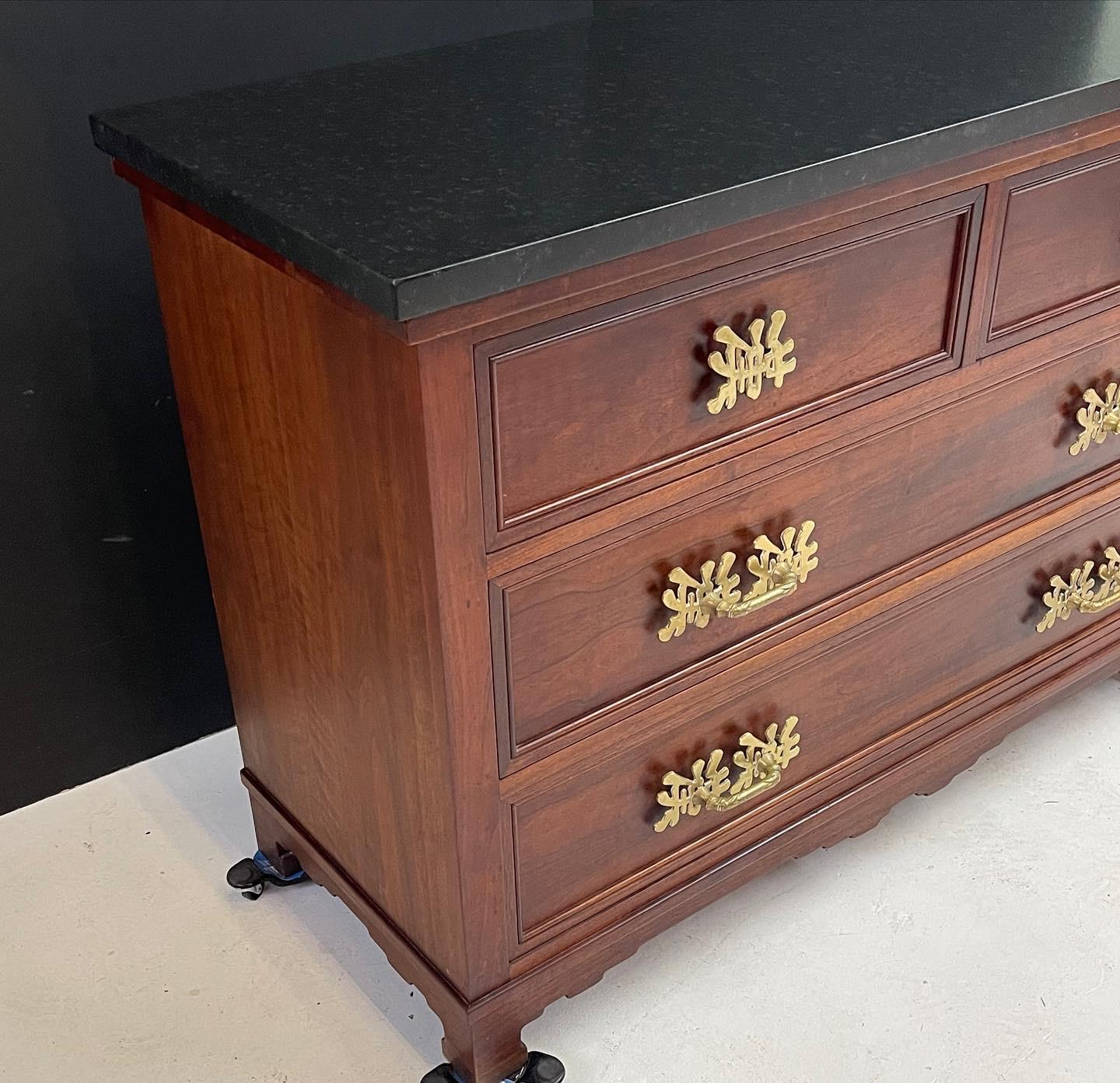 20th century fine quality chest of mahogany with a black leathered marble top over four beautifully paneled drawers. The case rests on four feet with connecting aprons all having Ming style details. Heavy cast bronze Chinese calligraphy characters