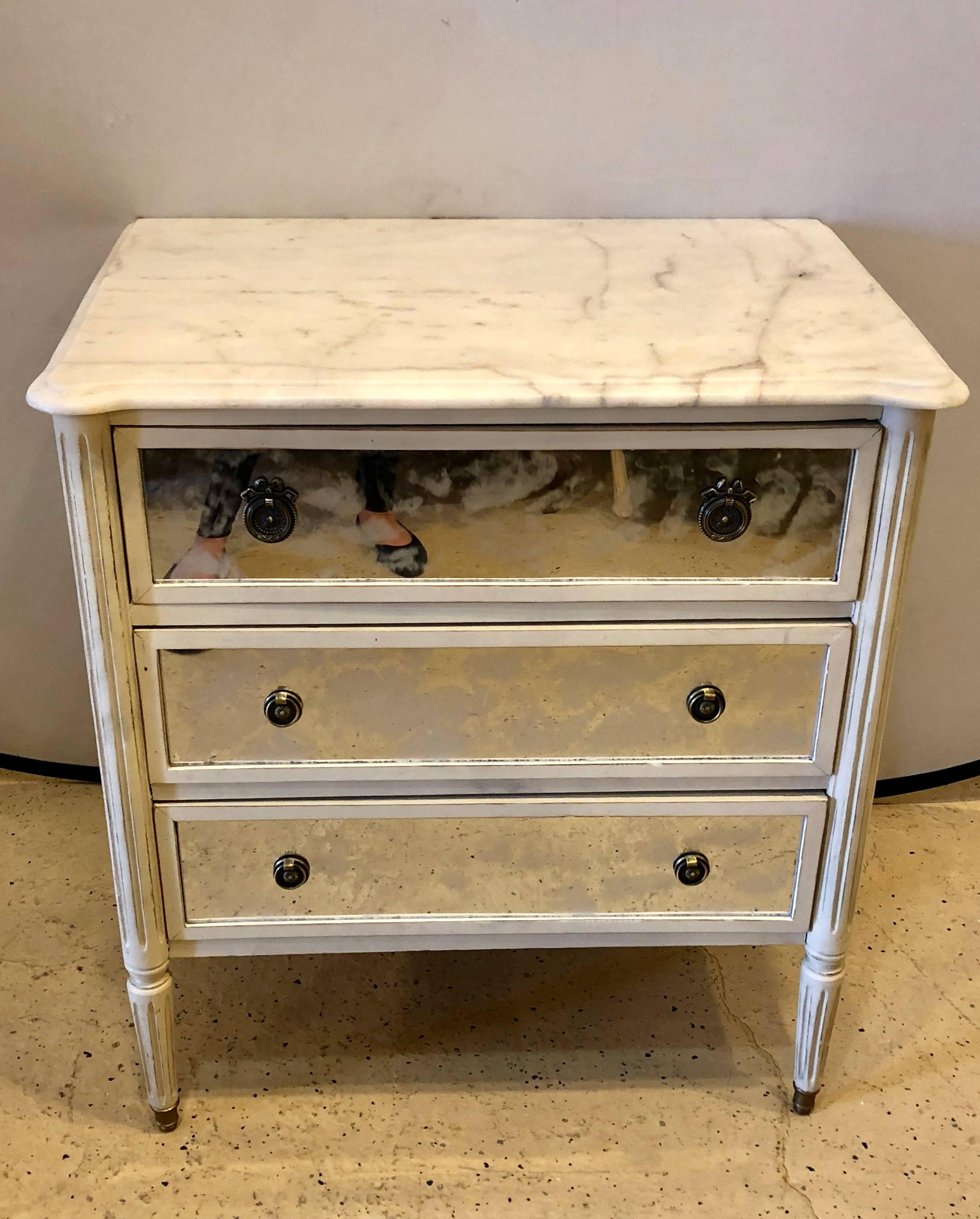 A Hollywood Regency style marble-top paint and Mylar decorated commode or nightstand in the Louis XVI style possibly by Maison Jansen.