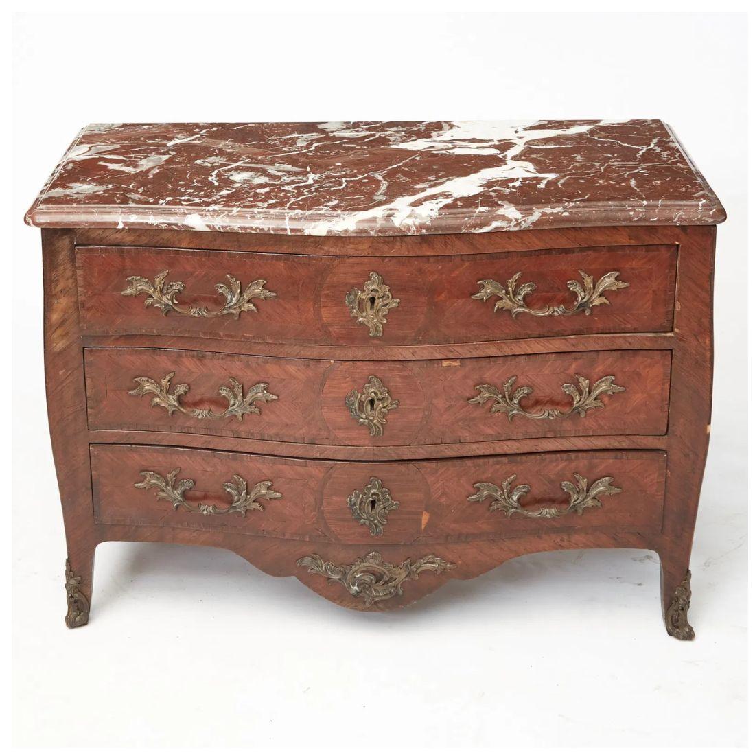 Questa graziosa cassettiera a tre cassetti in stile Luigi XV ha una forma graziosamente serpeggiante che aggiunge un tocco di eleganza a qualsiasi stanza. Il comodino è realizzato in pregiato legno Kingwood e presenta un intricato parquet che ne