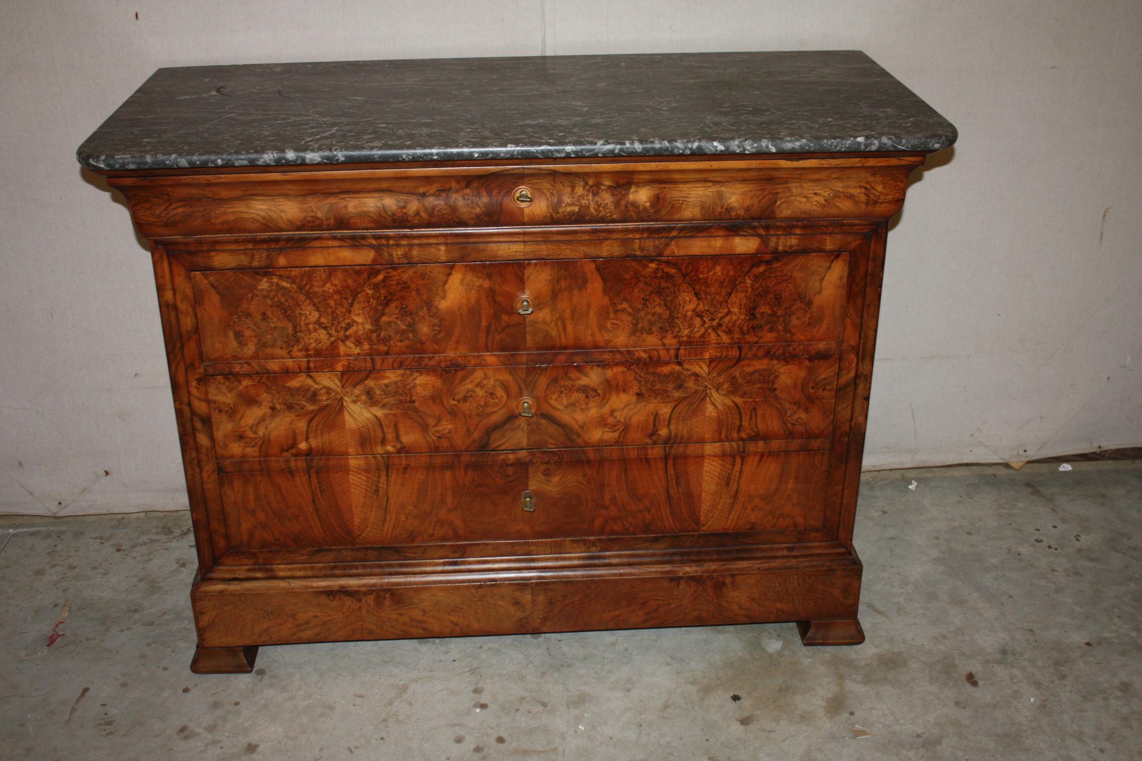 This is a spectacular Louis Phillip walnut commode with a rectangular marble top above and in-curving narrow frieze drawer over three long drawers raised on bracket feet. Beautiful rich patina!