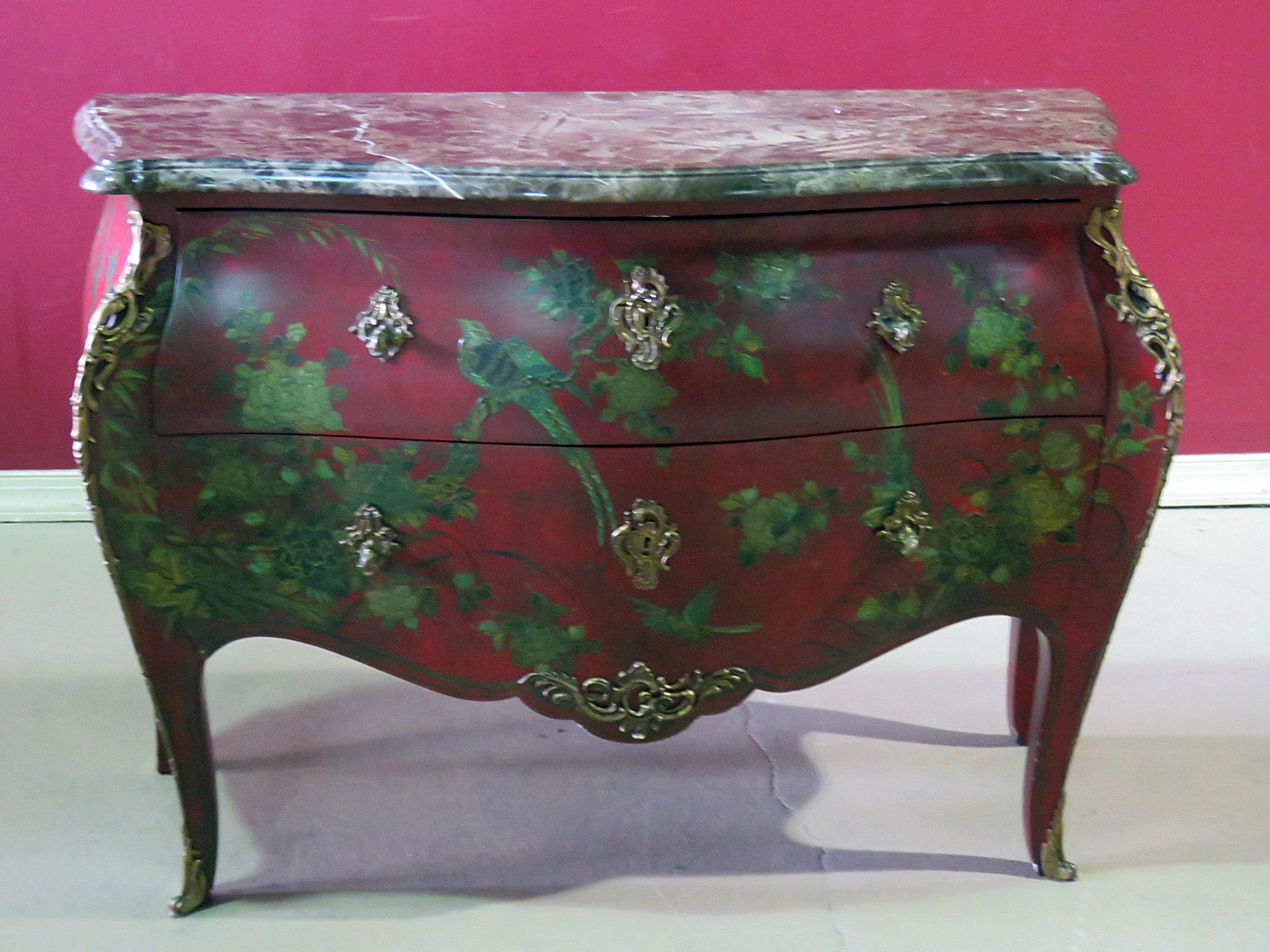 This is a fantastic red and green chinoiserie painted commode. The complimentary colors add a bright and lively look that is rather unique for commodes of this form. The piece features mythical birds and lush foliage. The painting is raised