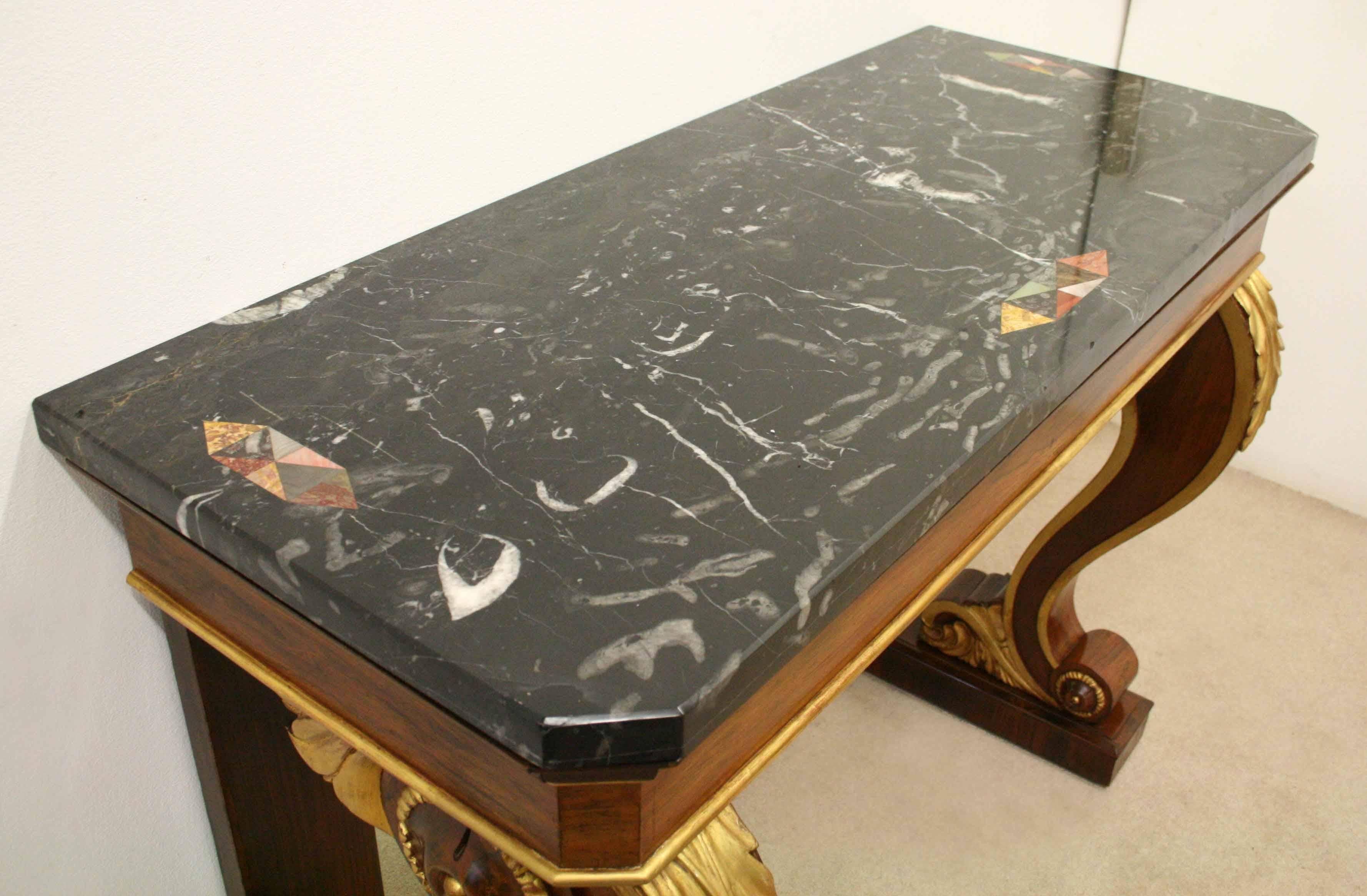 Very unusual and stylish marble topped rosewood and gilded console table, circa 1920. The marble top with its unusual inlaid panels on the front and sides in the form of diamonds with various semi-precious stones or marbles. Below this there is a