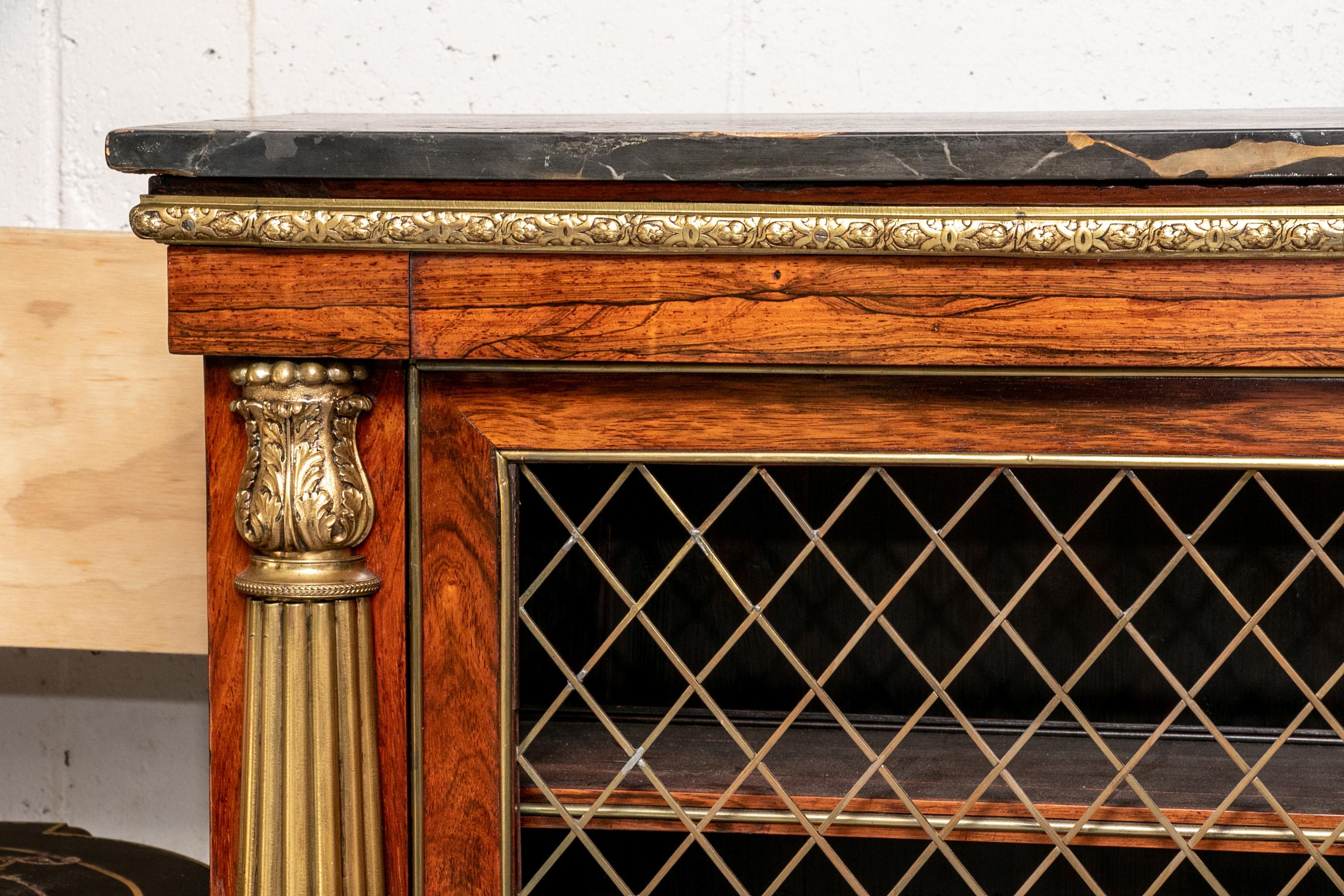 Marble-top server cabinet, double grille work doors opening to two shelves. With carved and gilt band across the top and fluted pilaster supports. With a black and brown marble top.

Condition: Expected wear and signs of use including repair to