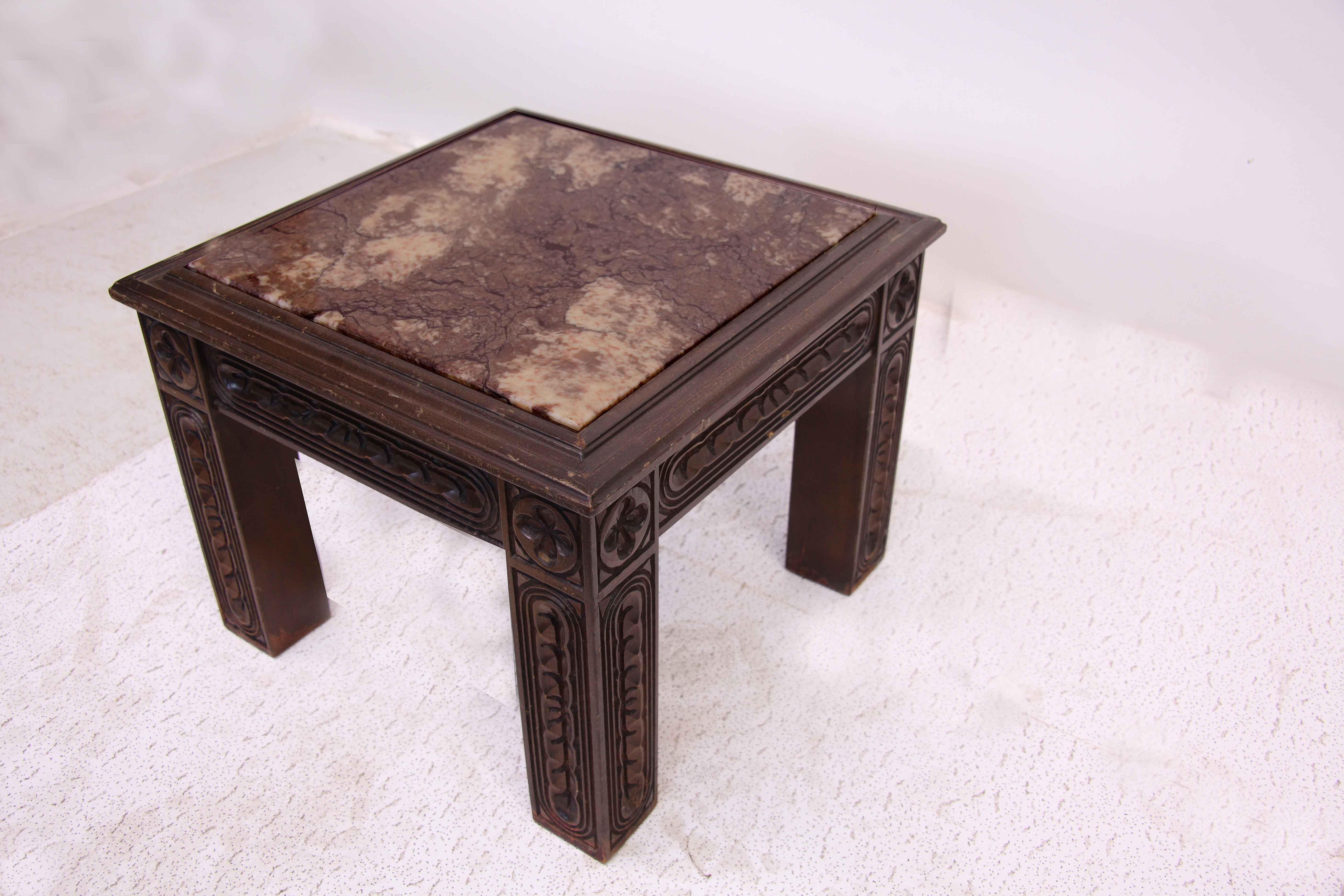 Marble top carved table, with beautiful veined marble top. The straight legs and rails are highly carved on all four sides, with a stylized four leaf clover at the top of each leg.