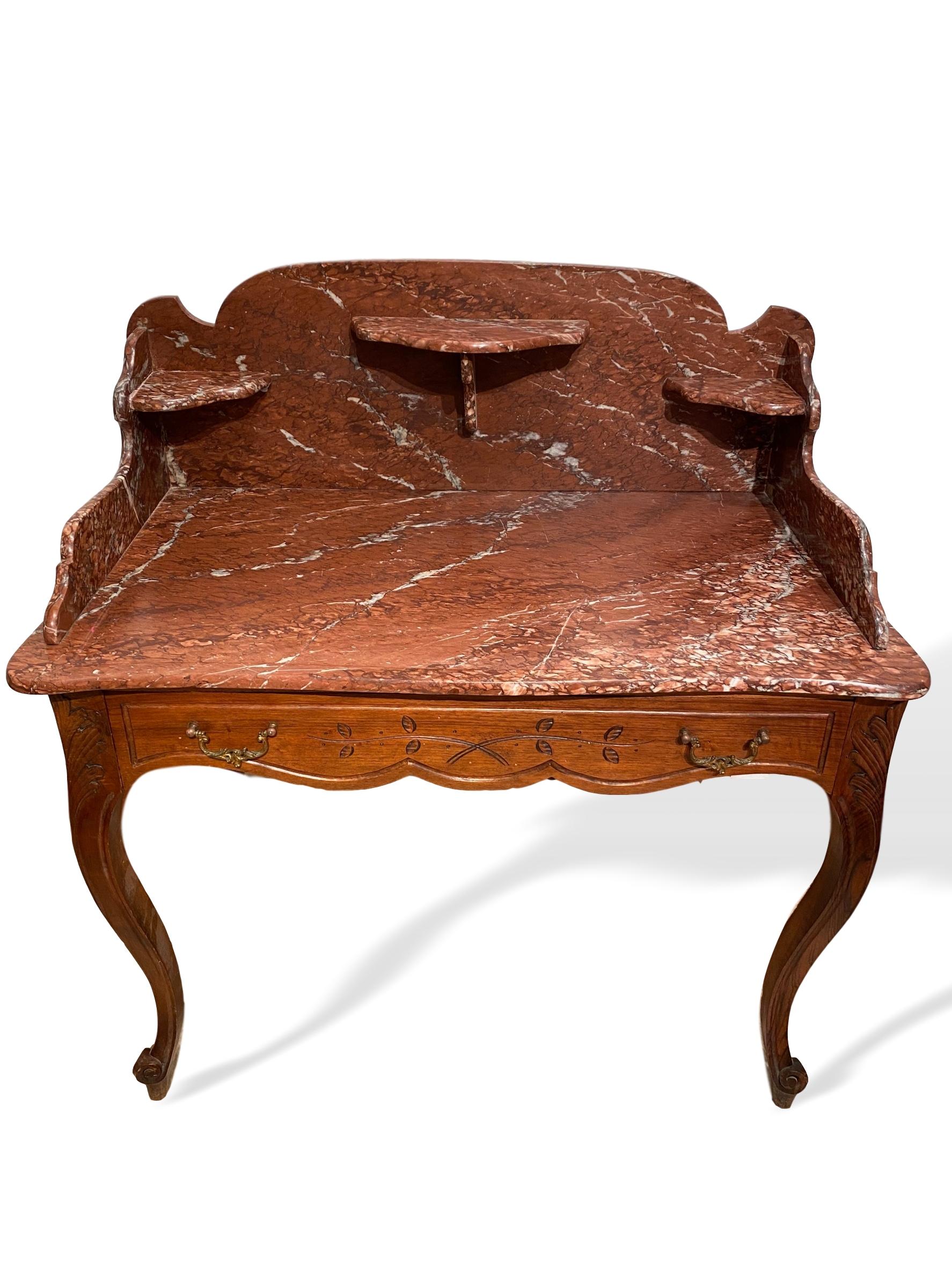 Marble-top washstand dry sink with marble surround and shelves, French, circa 1880, the stand in cherry, with a hand carved and shaped single drawer, with gilded bronze pulls, on curved French legs and whorl feet. 

Measures: 43.25