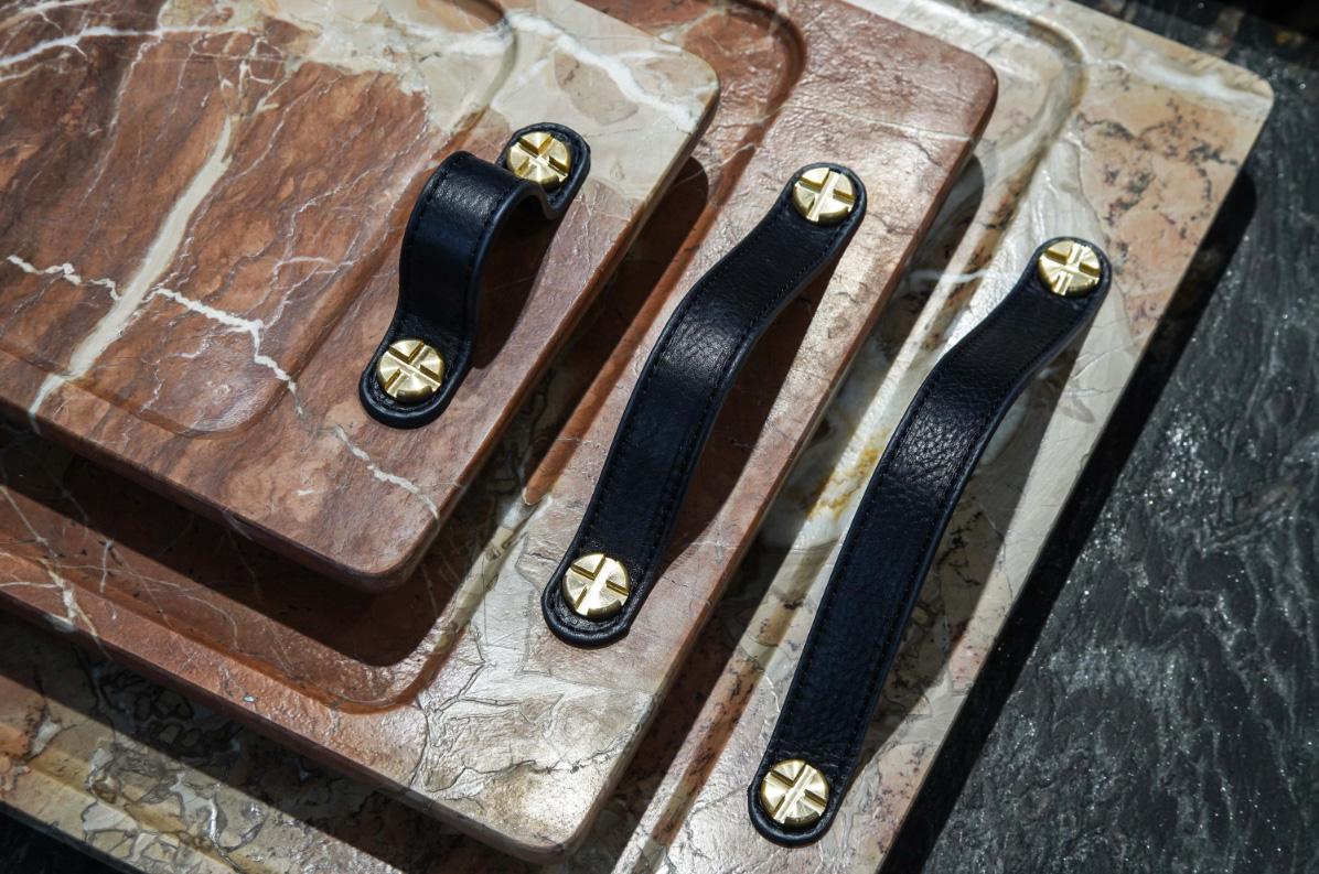 Marble trays with leather straps and brass bottom reinforcement. Leather tips on the legs to avoid scratching surfaces. 

Marble is a non-foliated metamorphic rock composed of recrystallized carbonate minerals, most commonly calcite or