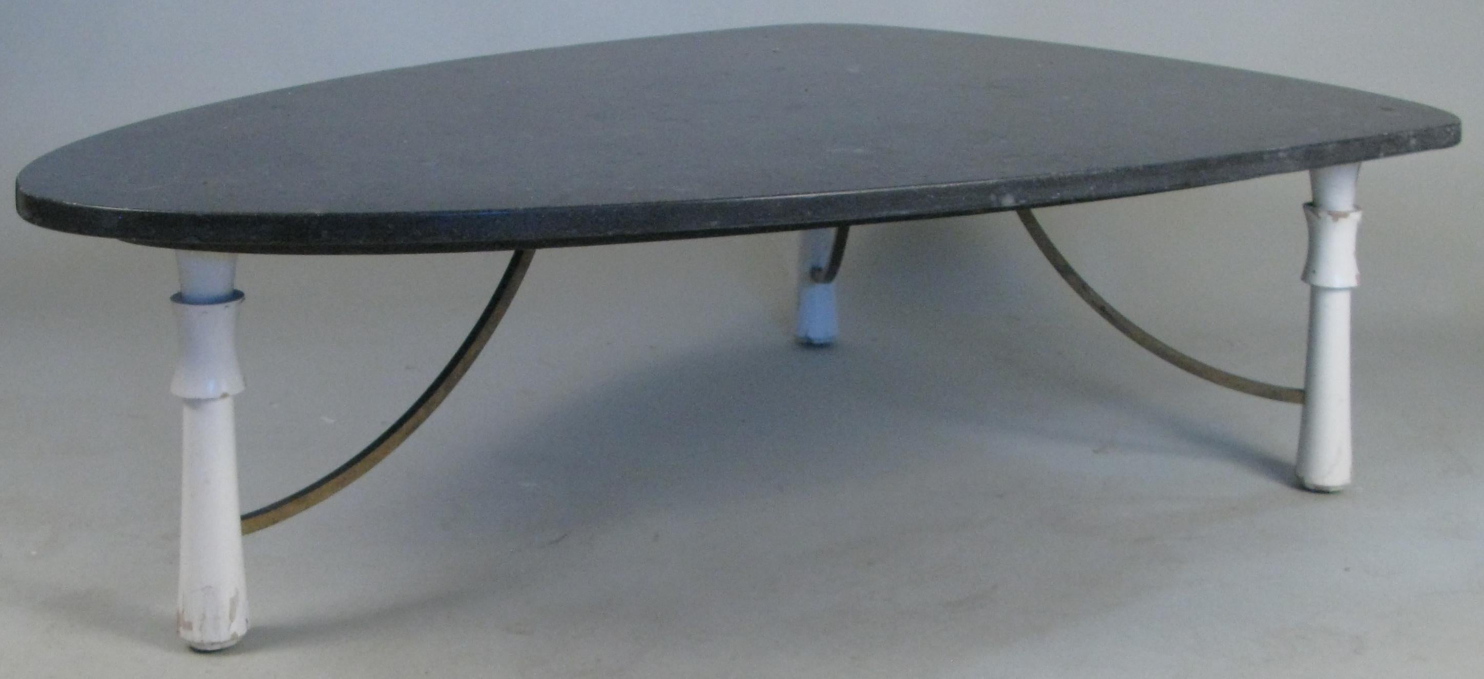 A beautiful 1950s triangular marble top cocktail table, with three leg base, the turned legs connected with brass supports. The dark grey marble top is in a triangle form with curved corners.