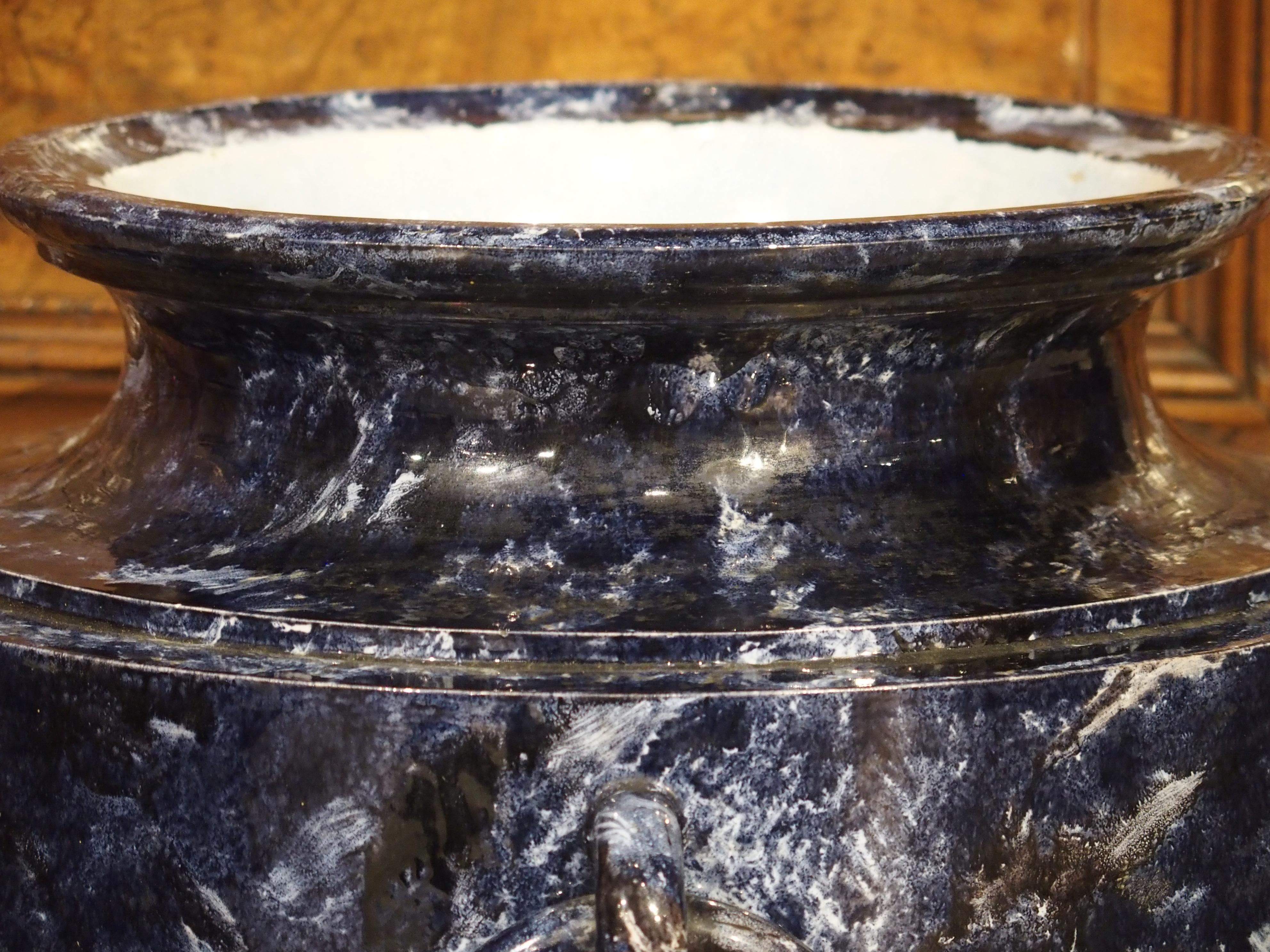 Proveniente da Sèvres, in Francia, questo grazioso vaso in porcellana è stato dipinto a mano in finto marmo blu con venature bianche e nere. Il vaso è stato prodotto nello stile di uno stamnos greco, che era un vaso progettato per conservare i