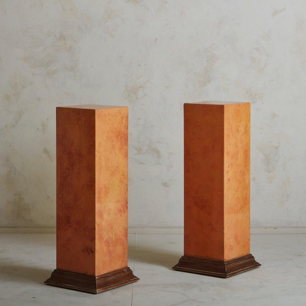 A pair of vintage French pedestals in a beautiful orange hue with a marbled lacquer finish. These pedestals have angled, stained wood bases. Sourced in France, 20th century. Two Available; Priced Individually. 

.