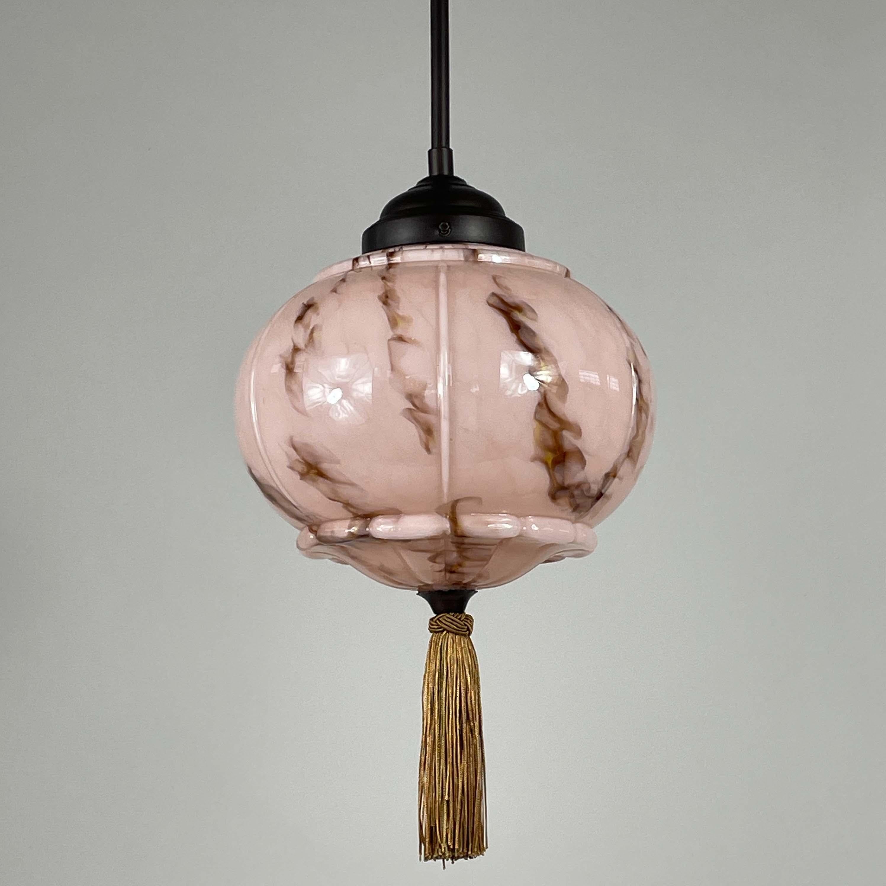 This elegant pendant was designed and manufactured in Germany during the Bauhaus Period in the 1920s to 1930s.

It features a pale rose colored opaline glass lampshade with brown and beige marbled decor, bronzed / burnished metal hardware and silk