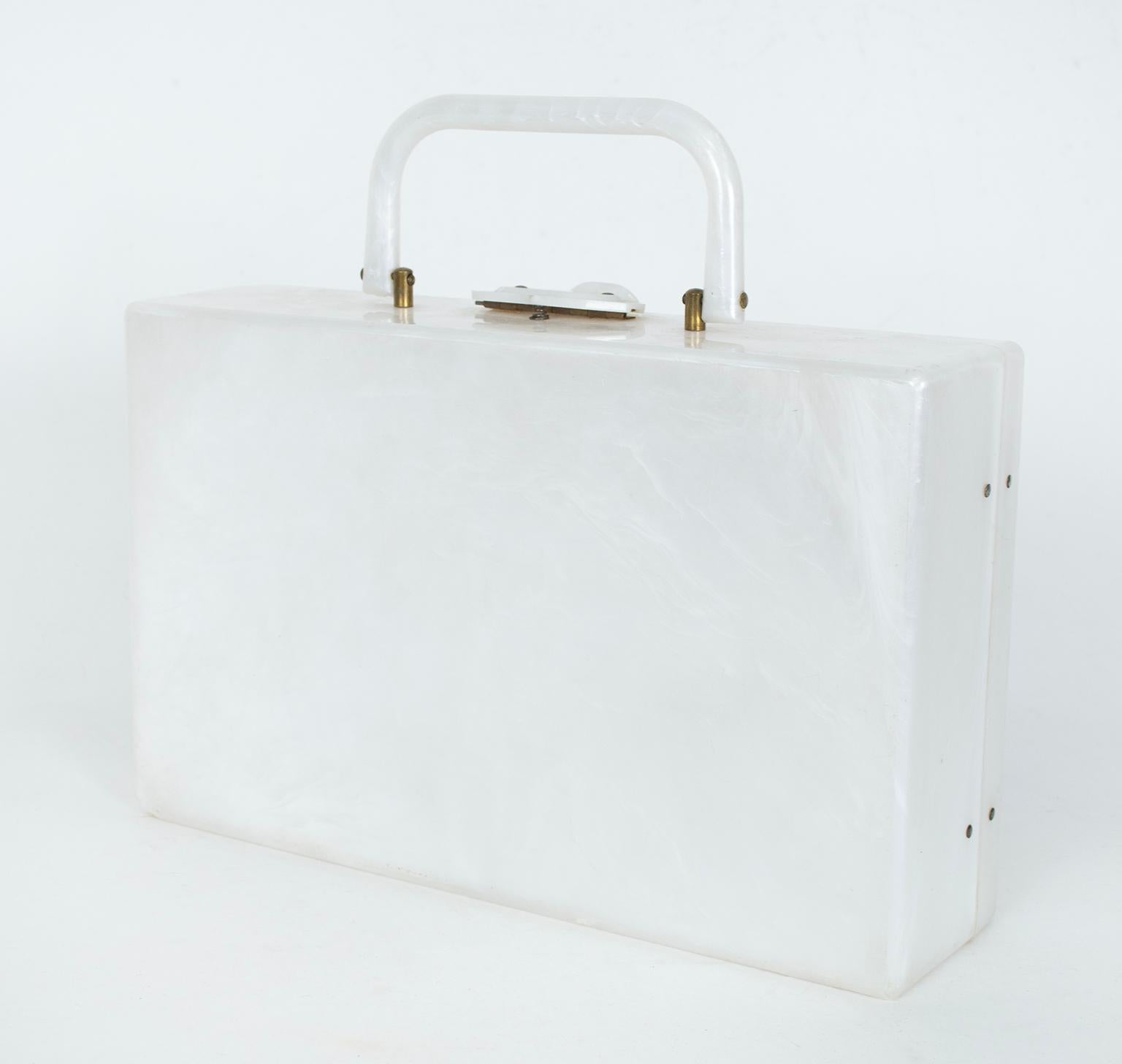 A rare suitcase-style Lucite purse, this statement piece is made even more interesting by the clear vinyl side bellows trimmed in gold. Both traditional and avant garde.

White marbleized Lucite suitcase purse with folding self top handle; hinged
