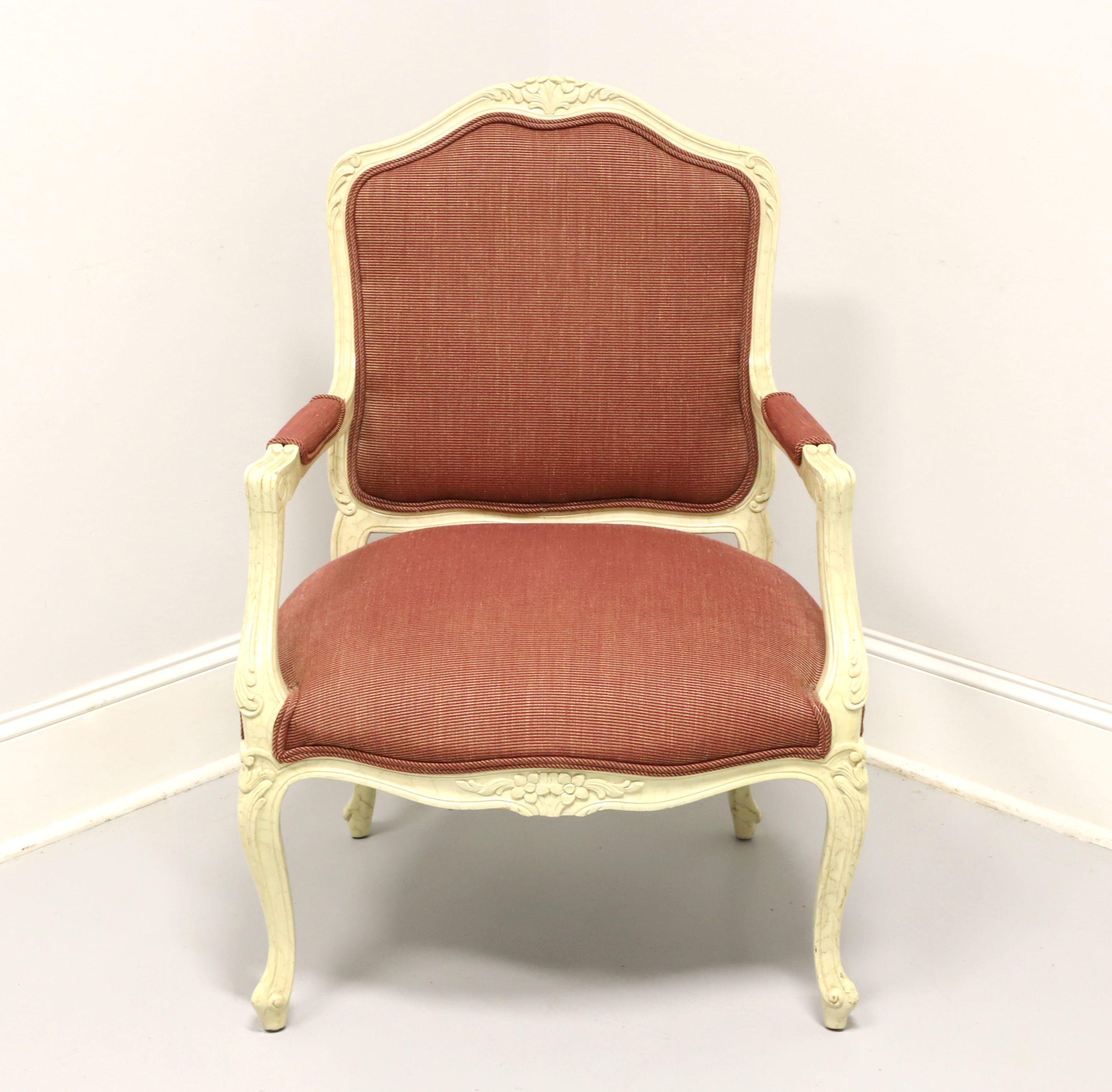 A French Louis XV style upholstered armchair, unbranded, similar quality to Drexel Heritage or Hickory Chair. Hardwood frame painted a marbleized cream color, burgundy color fabric upholstery, partially upholstered arms with carved supports, carved