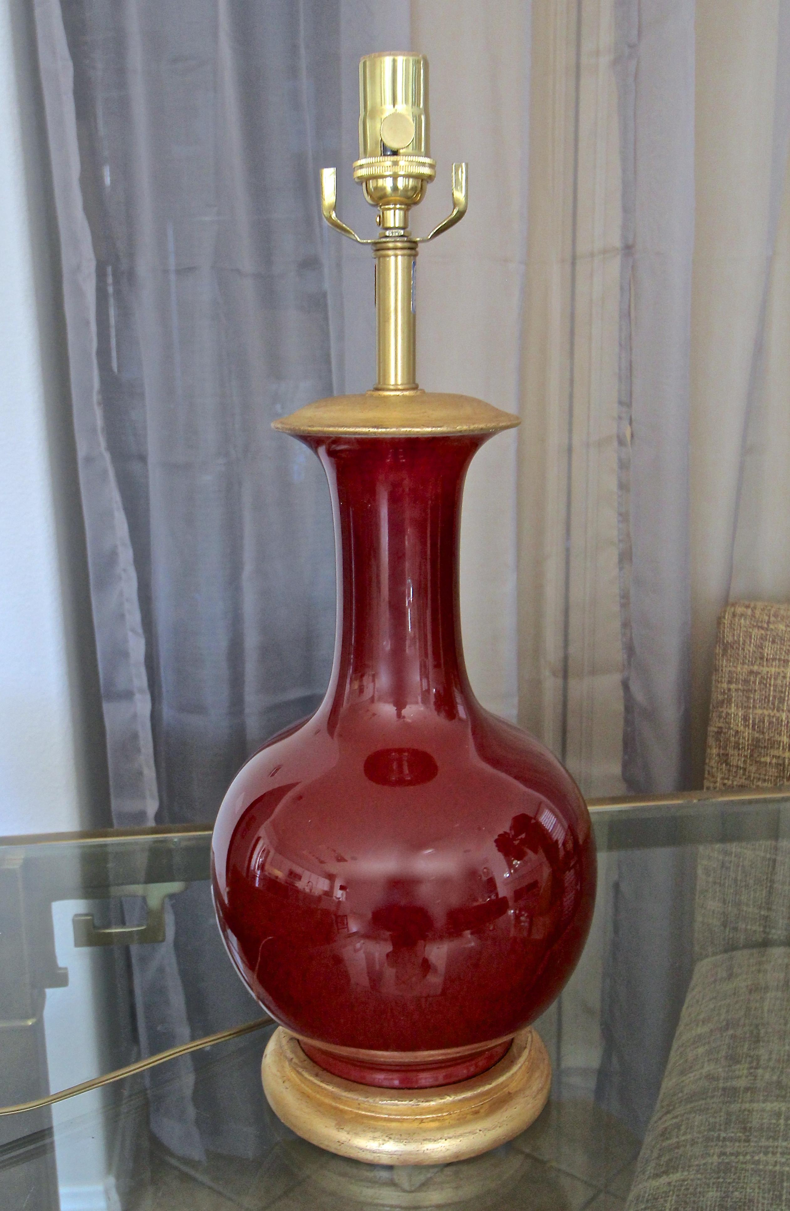 Chinese Asian Sang de Boeuf oxblood porcelain vase mounted on gilt turned wood lamp base by Marbro Lamp Company. The vase has a rich deep oxblood color. Rewired with new 3 way brass socket and cord.
Measures: Height top of socket 21