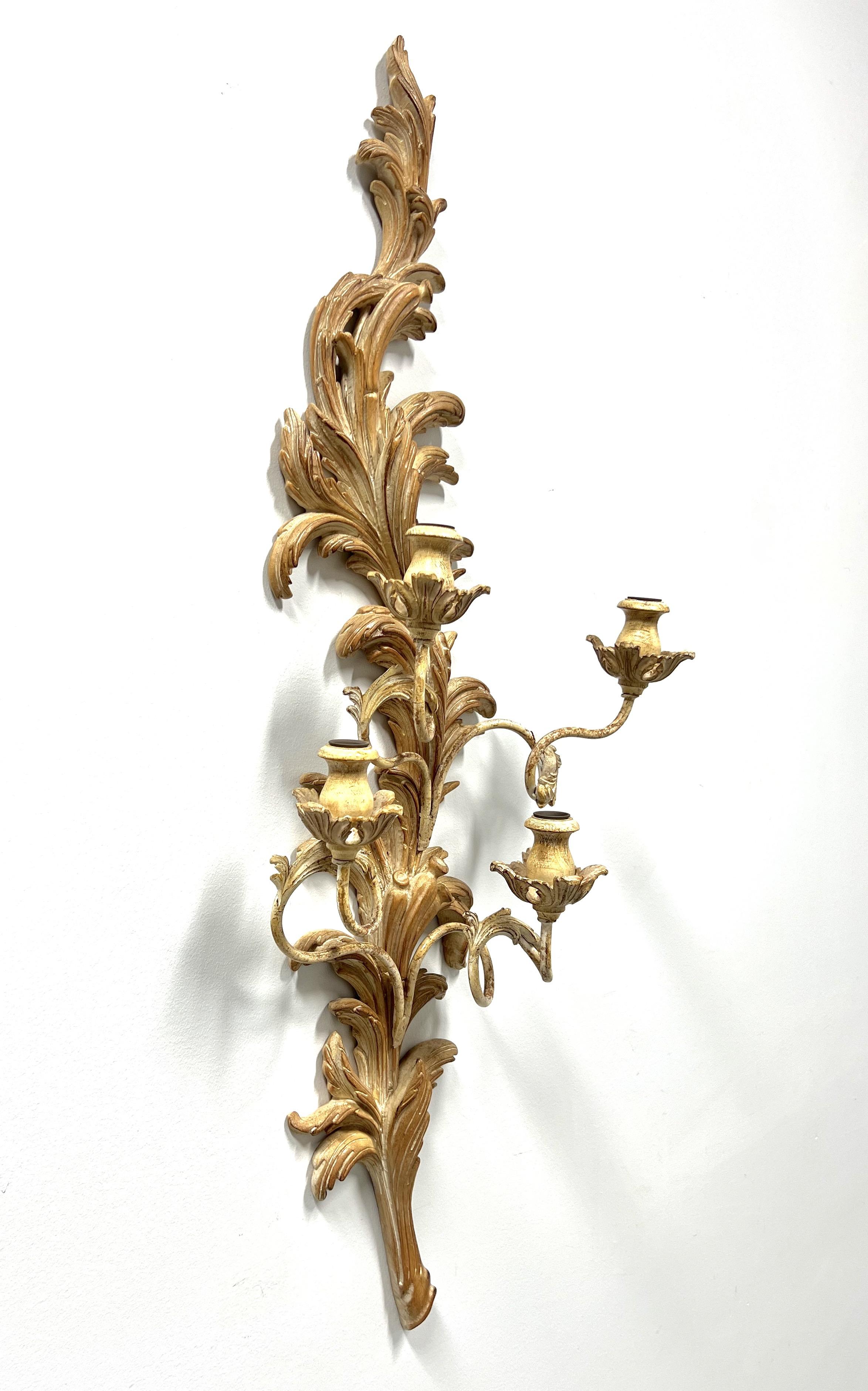 A Rococo style candle wall sconce by Marbro Lamp Company, of Los Angeles, California, USA. Solid wood with a whitewashed finish, decoratively carved in a foliate form, with four swirled arms and candleholders. Clip hanger to back for wall hanging.