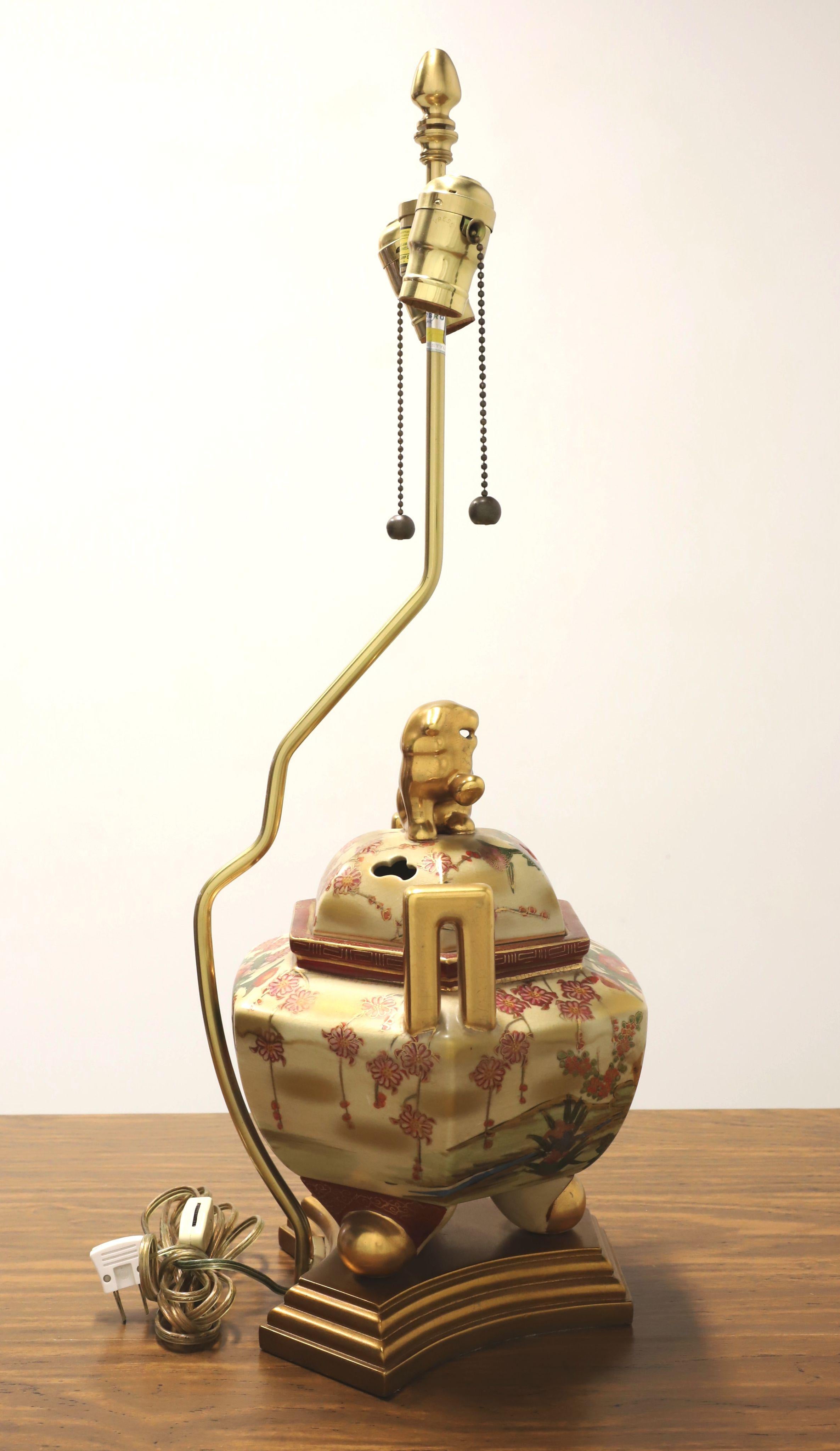 An Asian chinoiserie style table lamp by Marbro Lamp Co. Made of porcelain in an urn style, hand painted with a multi-color chinoiserie scene with gold accents, gold painted handles, gold painted foo dog to top of urn, and on a decorative tiered