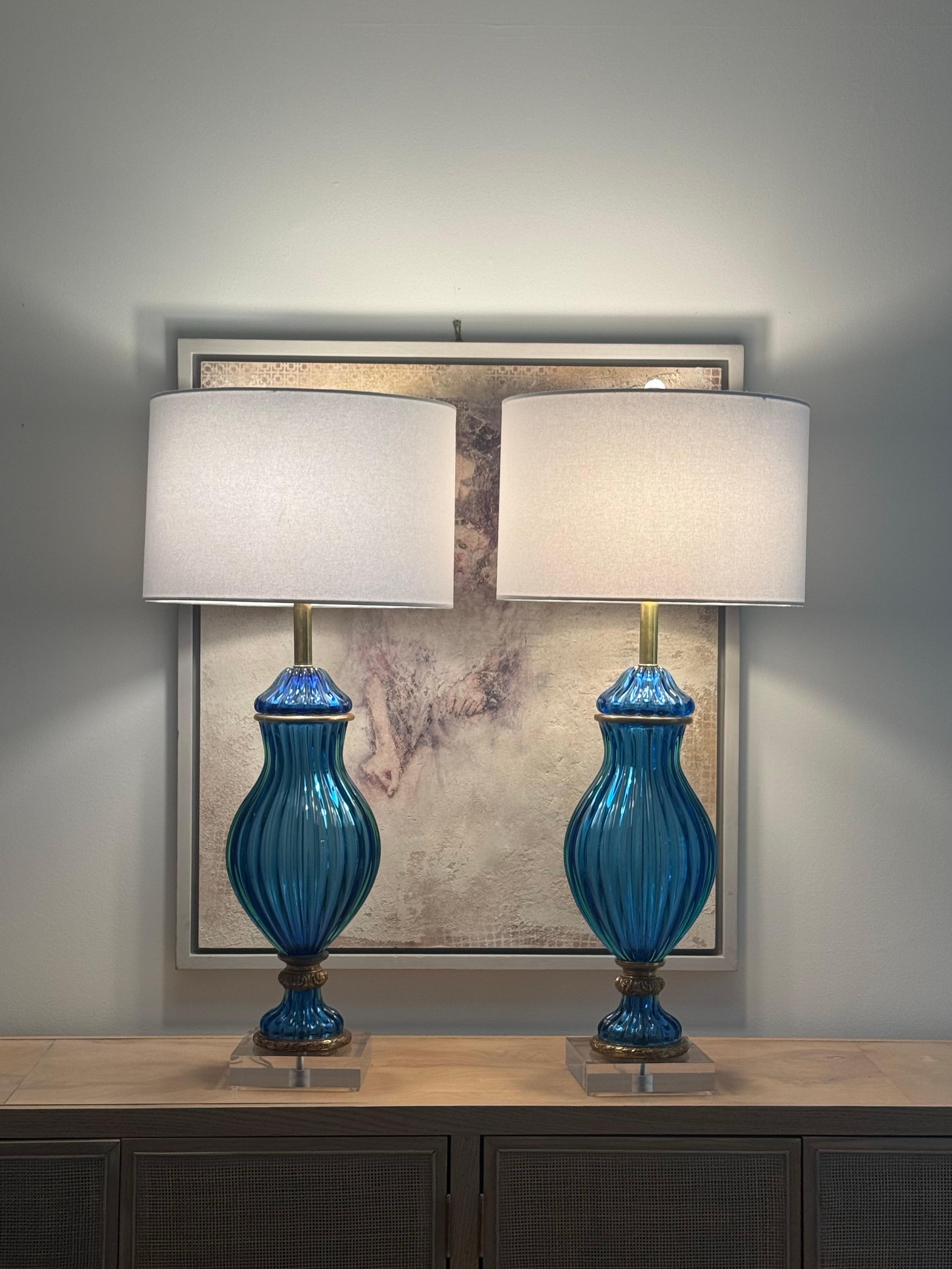 Wow! Absolutely stunning pair of Marbro blue Murano art glass double socket table lamps with brass trim. As you can see in the close-up photos, these amazing lamps give a green glow on the edges, in certain light. They are magical!

These wonderful