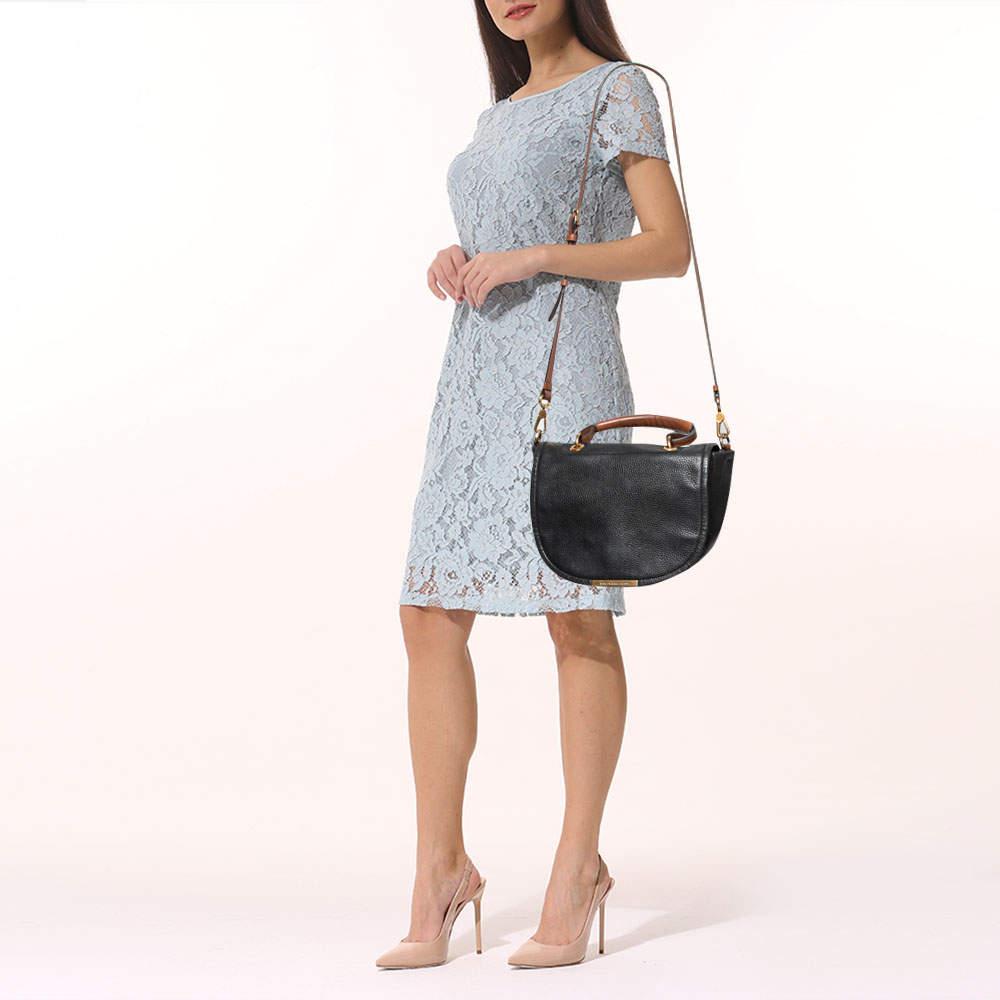 Carry your essentials hassle free with the fabric lined interior of this Marc by Marc Jacobs bag. Crafted from leather it displays a top handle a shoulder strap and a fabric lined interior. The brand detailing on the front offers it a recognizable