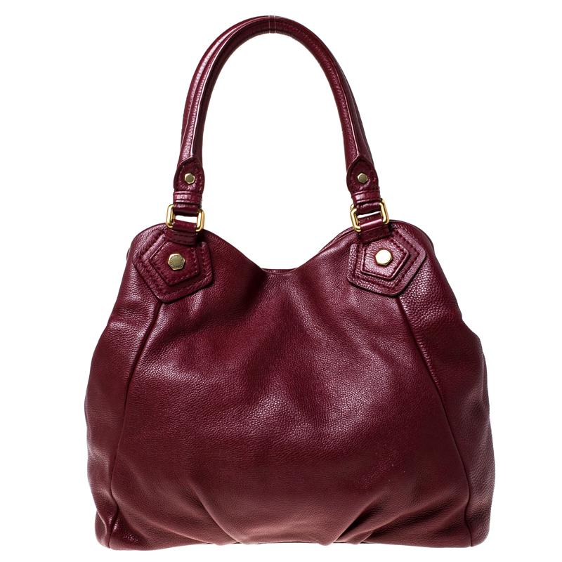 Elegant and classy, this Marc by Marc Jacobs bag would be a significant addition to your collection. Crafted from burgundy leather, it comes with a spacious satin-interior that will hold all your daily essentials. It features dual top handles and