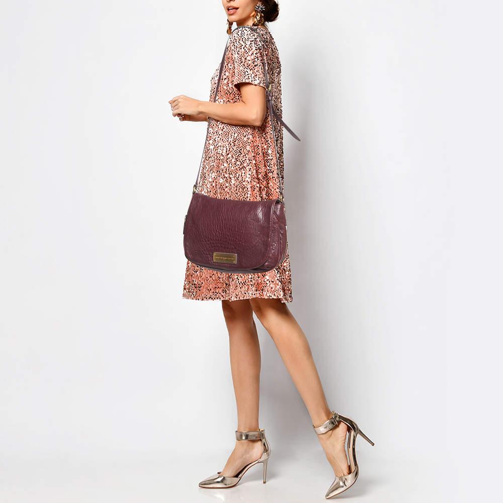 Marc by Marc Jacobs brings a classic piece which is bound to get heads turning. Crafted from leather  the bag is a rich burgundy in color and the subtle texture gives it an extremely sophisticated appearance. It a spacious interior and a brand