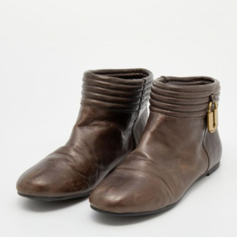 ¡Prepárate para cautivar a la multitud con estos sofisticados botines de Marc by Marc Jacobs! Las botas de piel vienen en un precioso tono marrón metalizado y muestran un diseño sencillo pero chic. Tienen llamativos detalles en los laterales y
