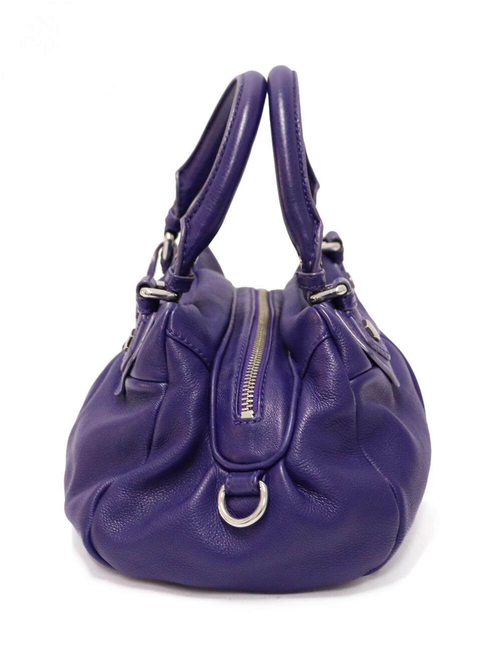 Marc by Marc Jacobs Purple Leather Classic Q Baby Groovee Bag, features two top handles, an adjustable shoulder strap, and the classic signature tag.

Material: Leather.
Hardware: Silver.
Height: 19cm
Width: 31cm
Depth: 12cm
Strap Length:
